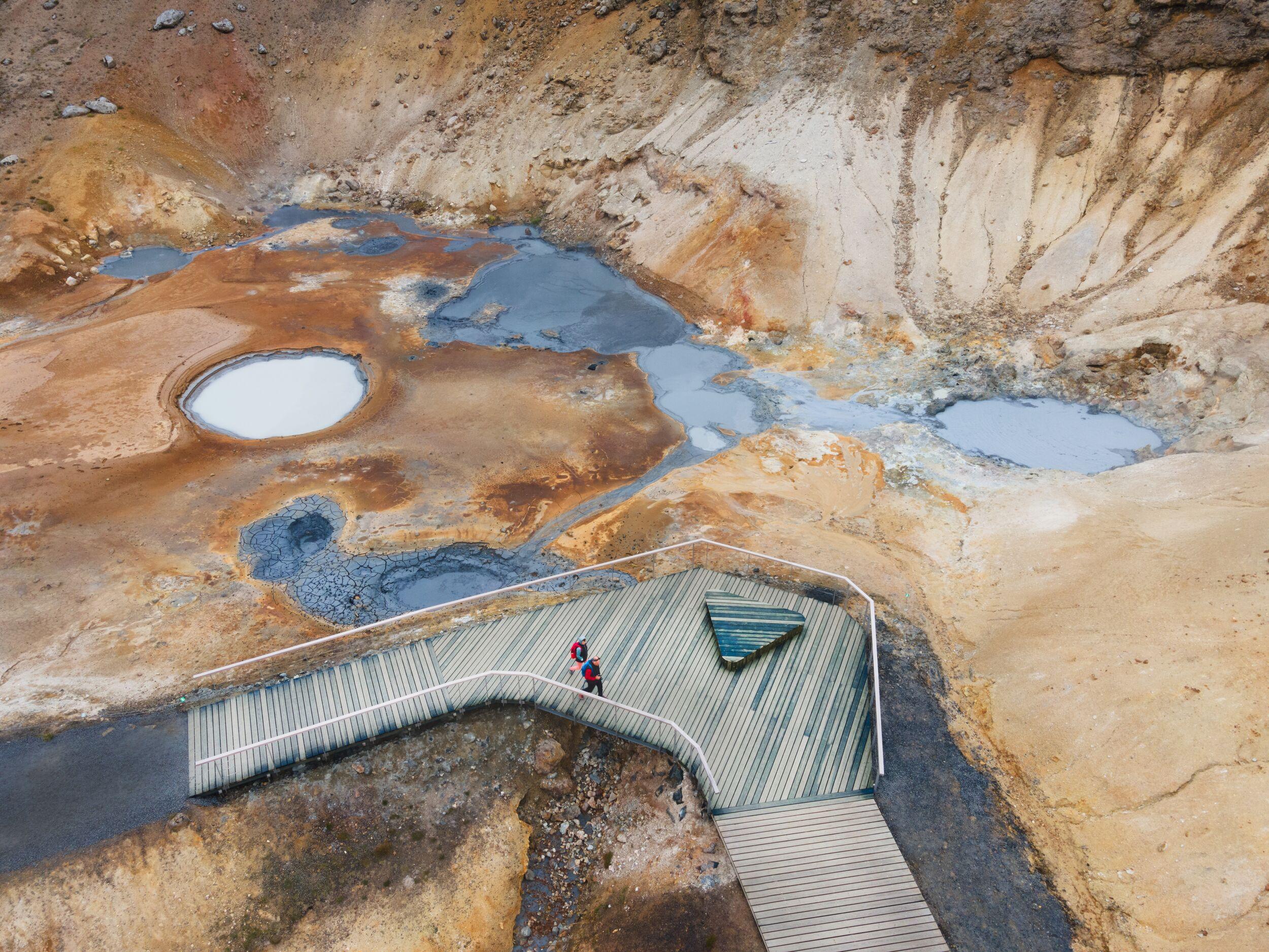 Aerial view of steaming Seltún geothermal area with volcanic features.