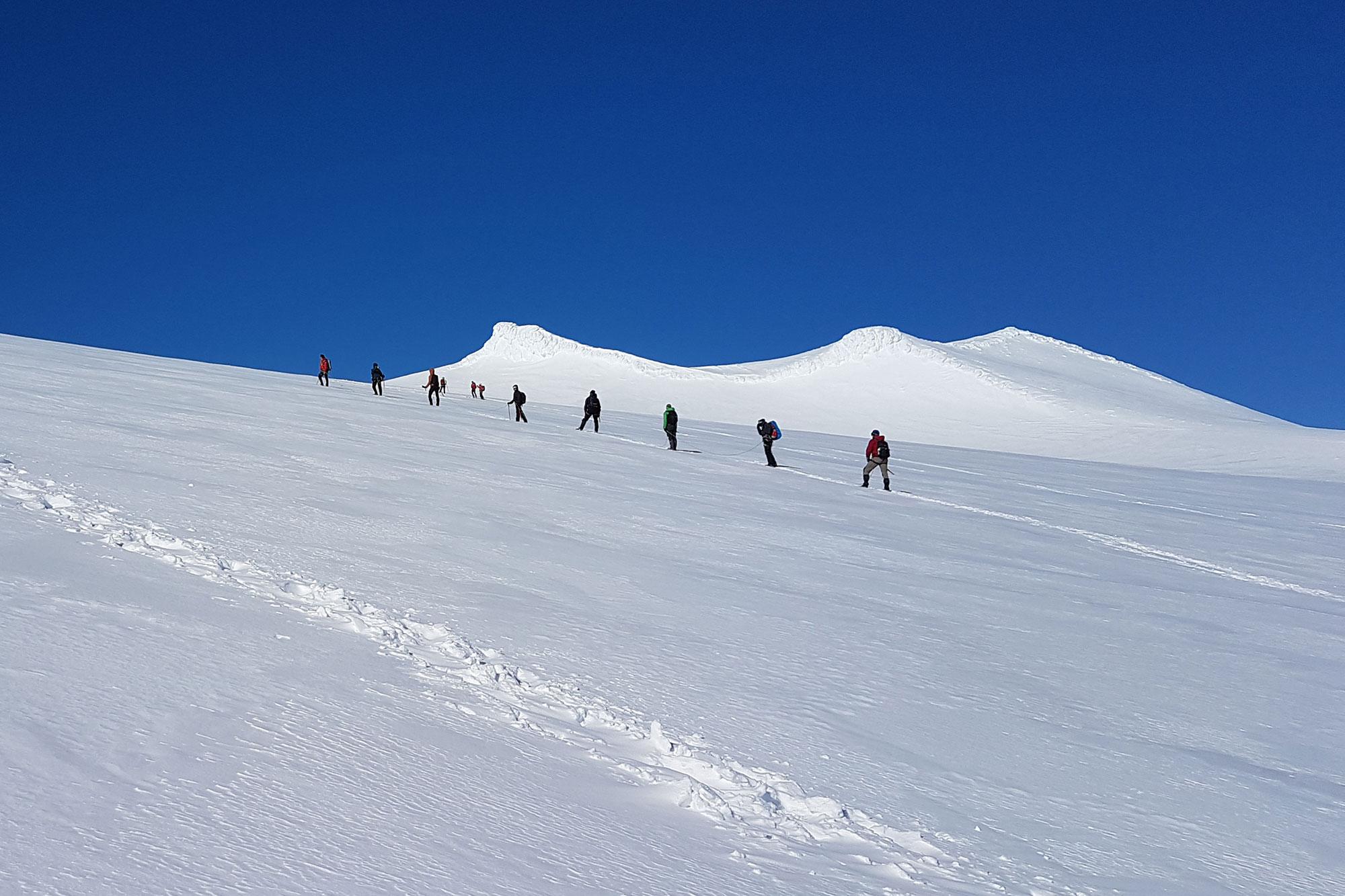 Group of people roped up on a glacier hiking up Snaefellsjokull glacier