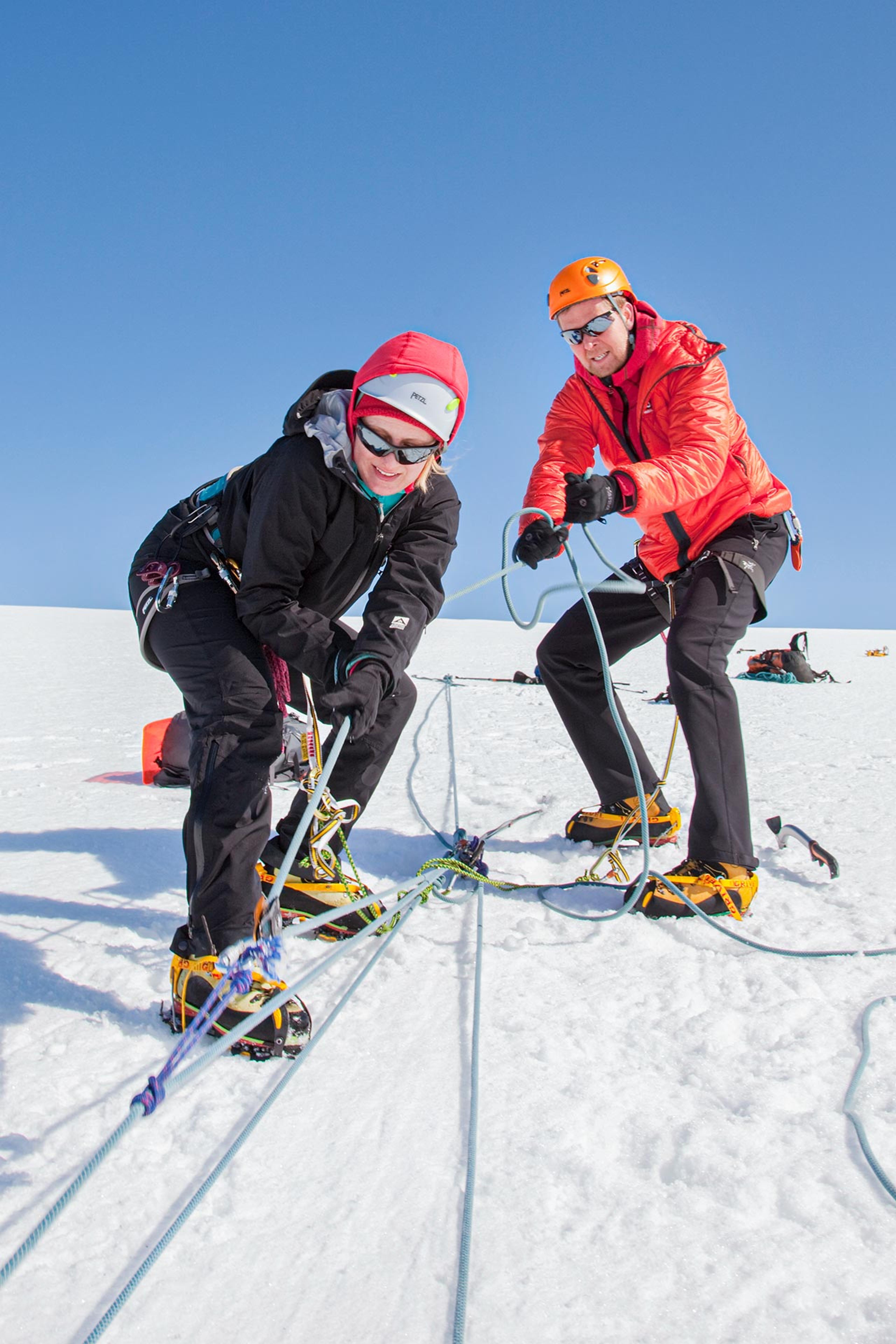 A couple training to rescue a person out of a crevasse