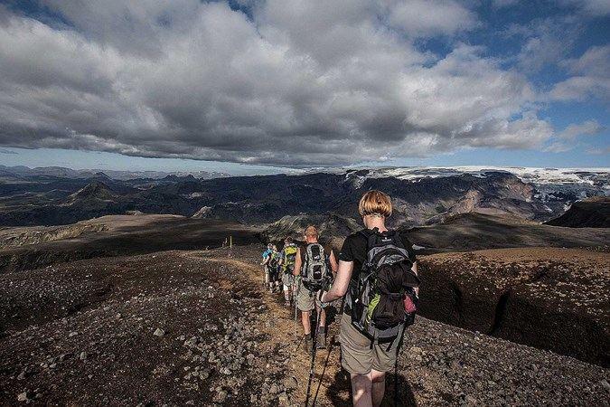 People hiking at Fimmvörðuháls with view of many mountains
