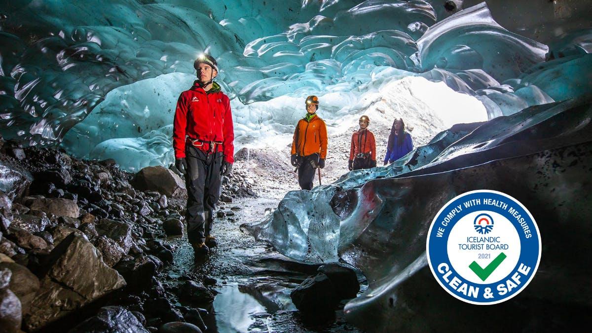 Glacier guide in an ice cave with customers