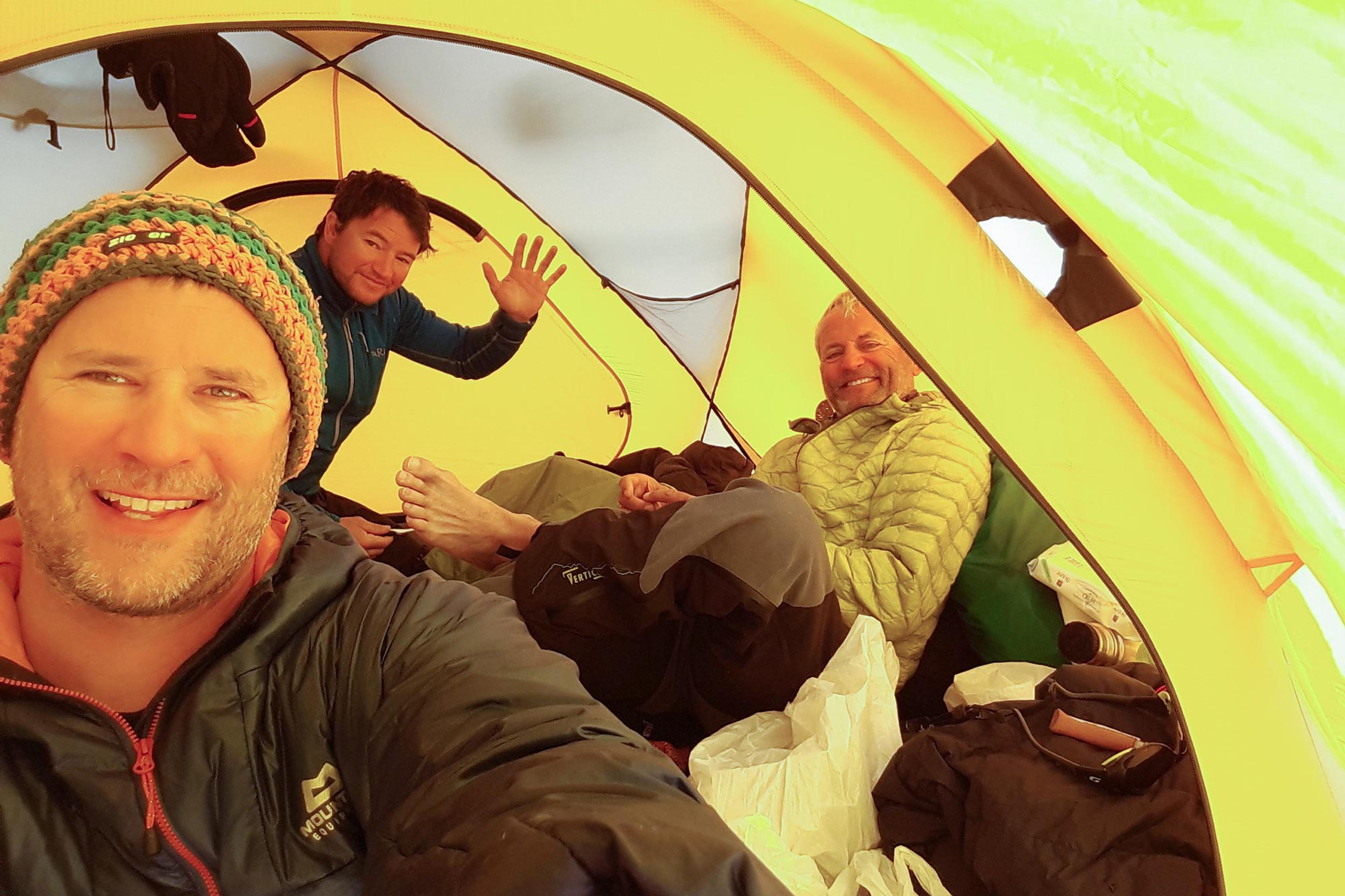 Three guys happy inside an expedition tent in Greenland
