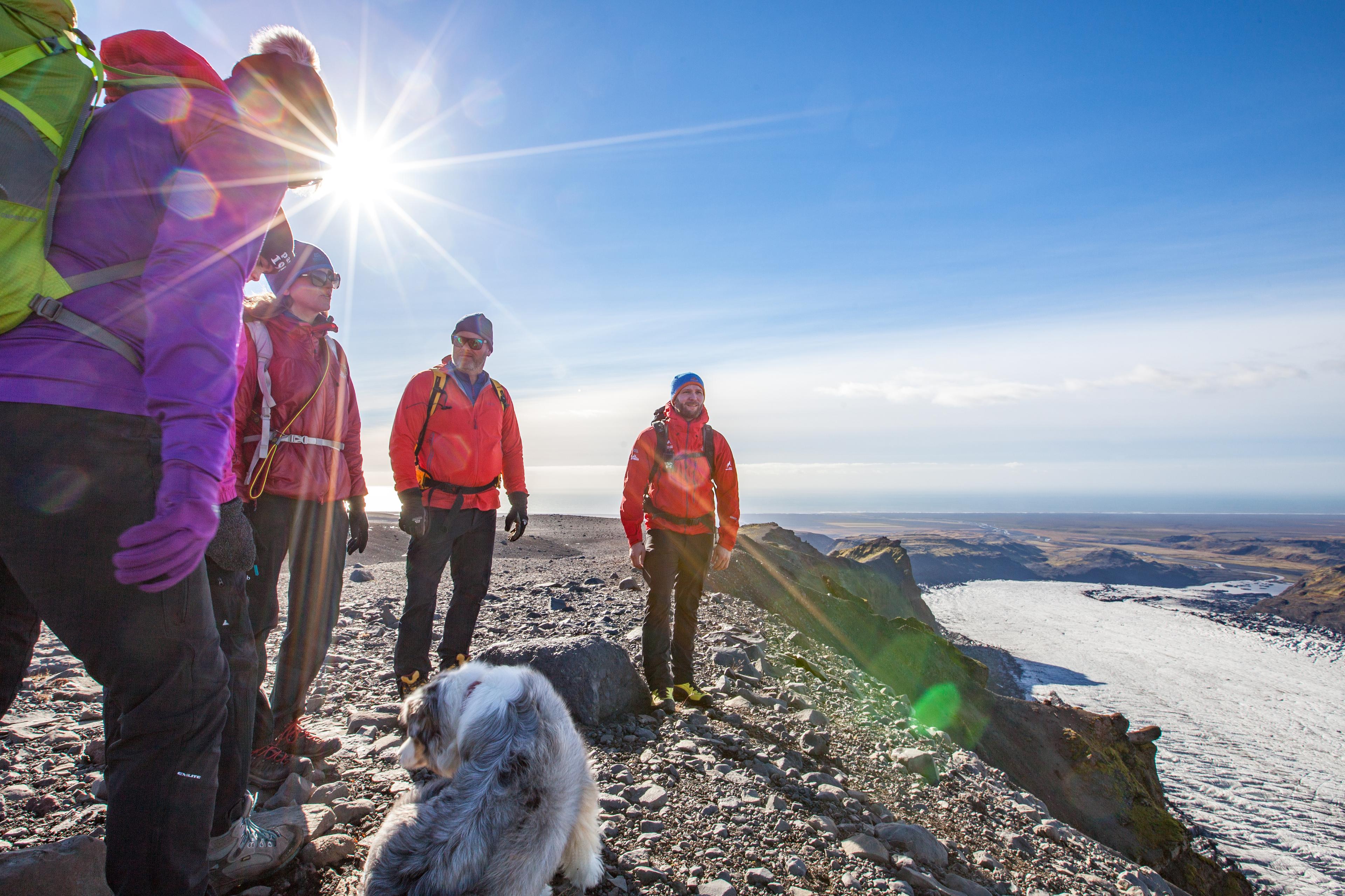The group of hikers standing close to the edge looking down on Sólheimajö0kull glacier