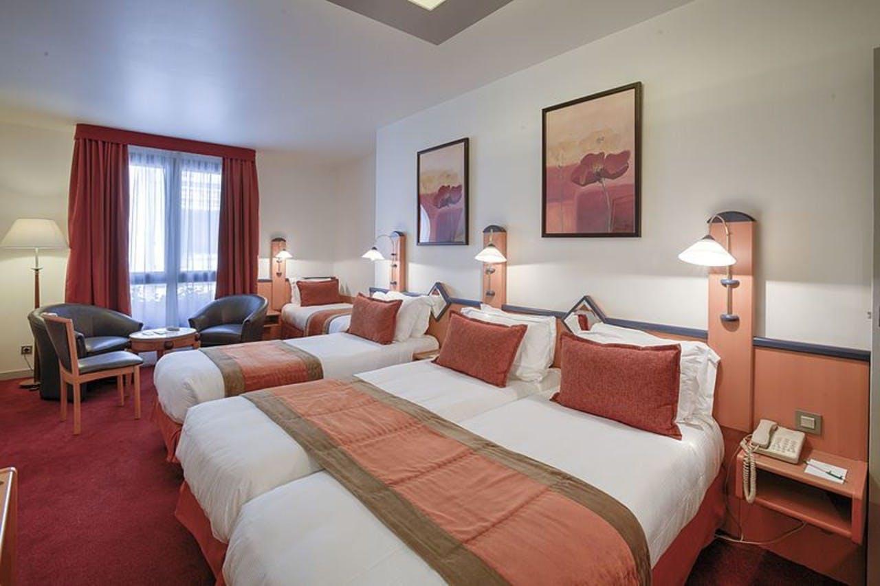 hotel room with four beds and a coffee table