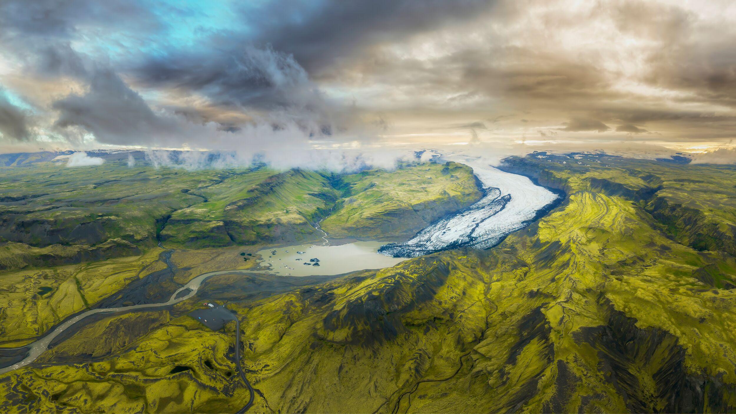 Aerial view of Sólheimajökull glacier, winding through Iceland’s mossy valleys.