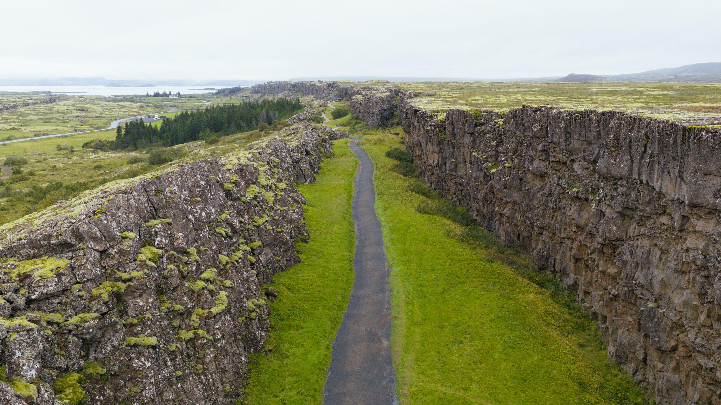 almannagja seen from above with a walking path and cliffs on each side