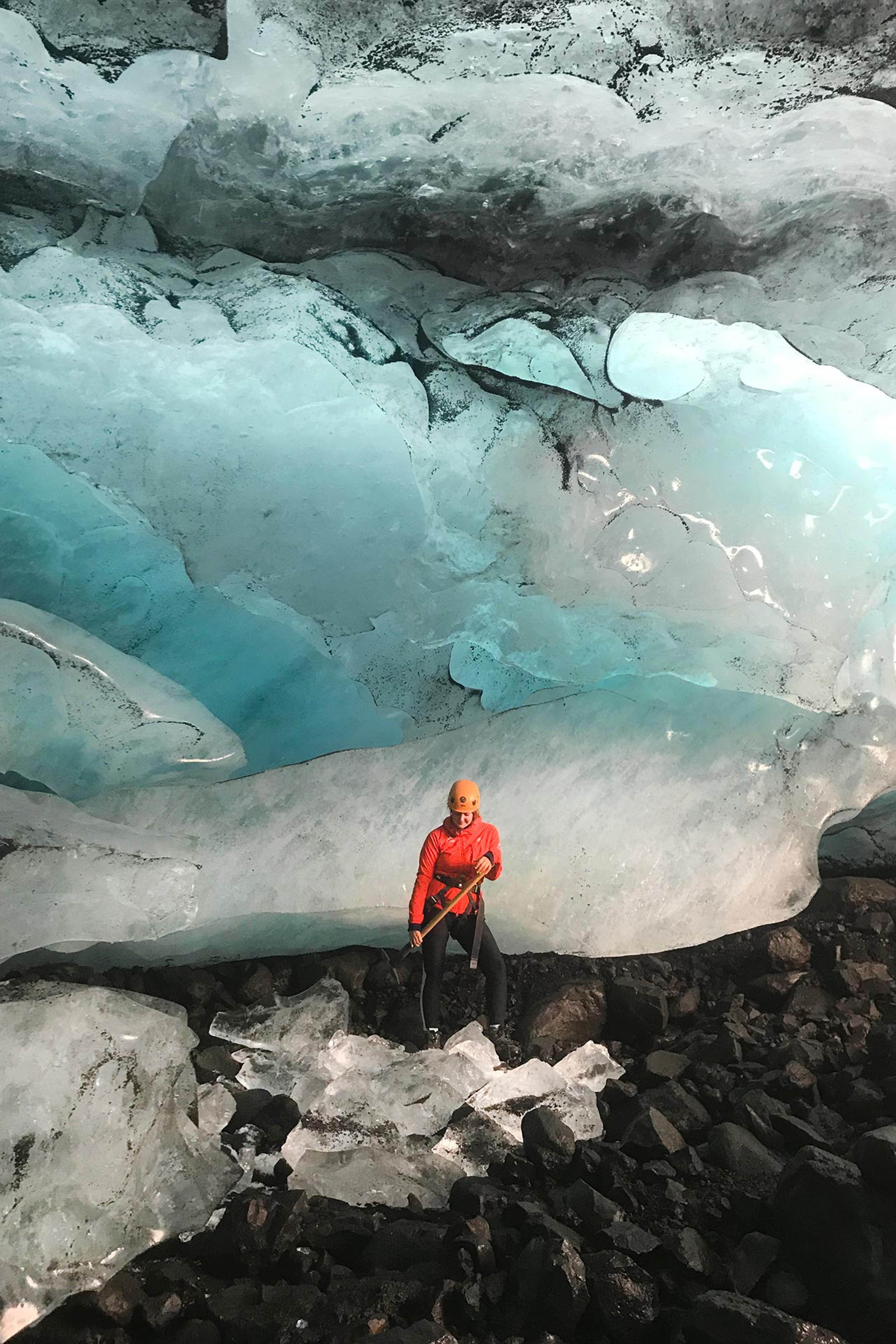 A girl standing with an ice pick under blue ice