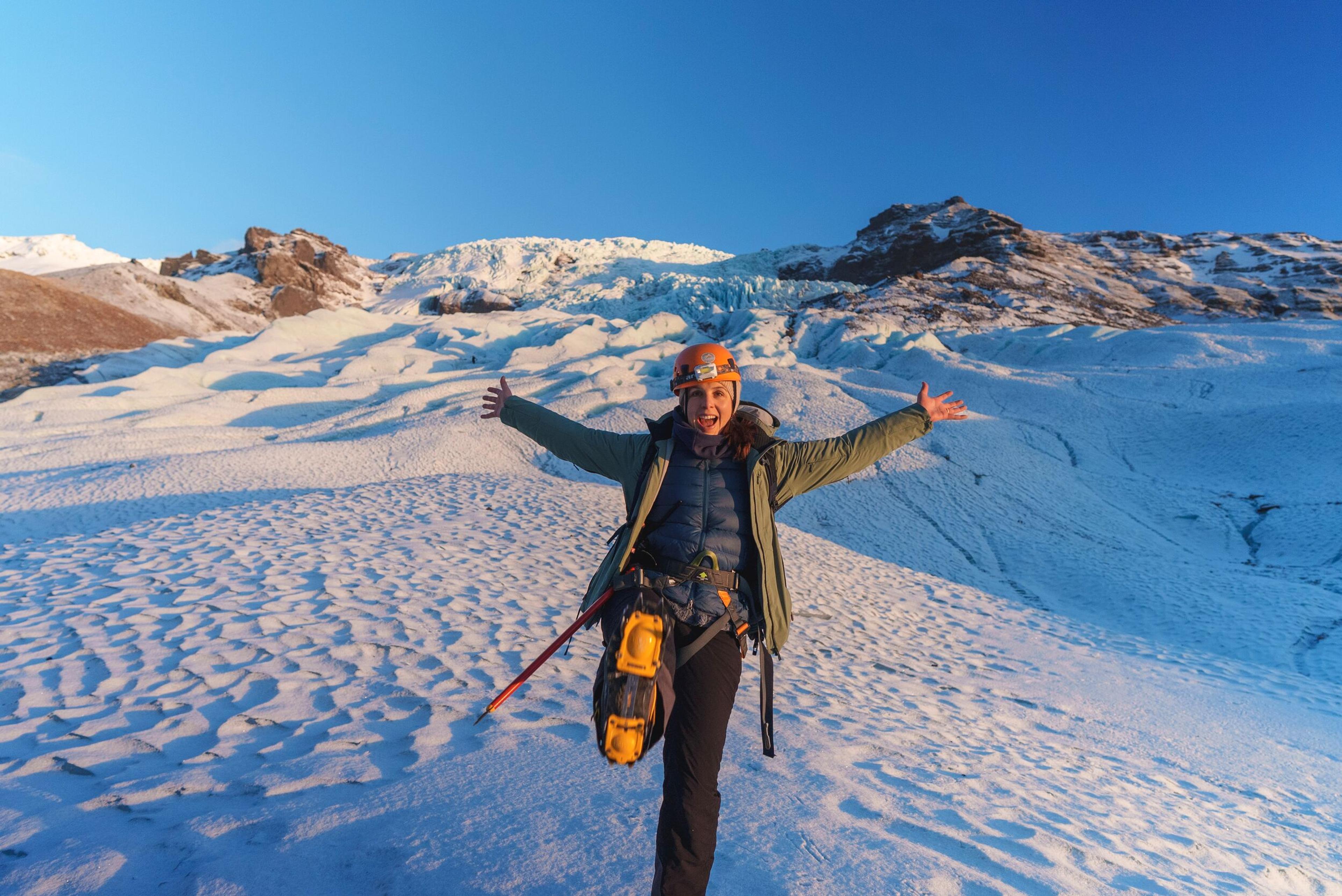 A lone hiker walks among blue ice walls on the Vatnajökull glacier.
