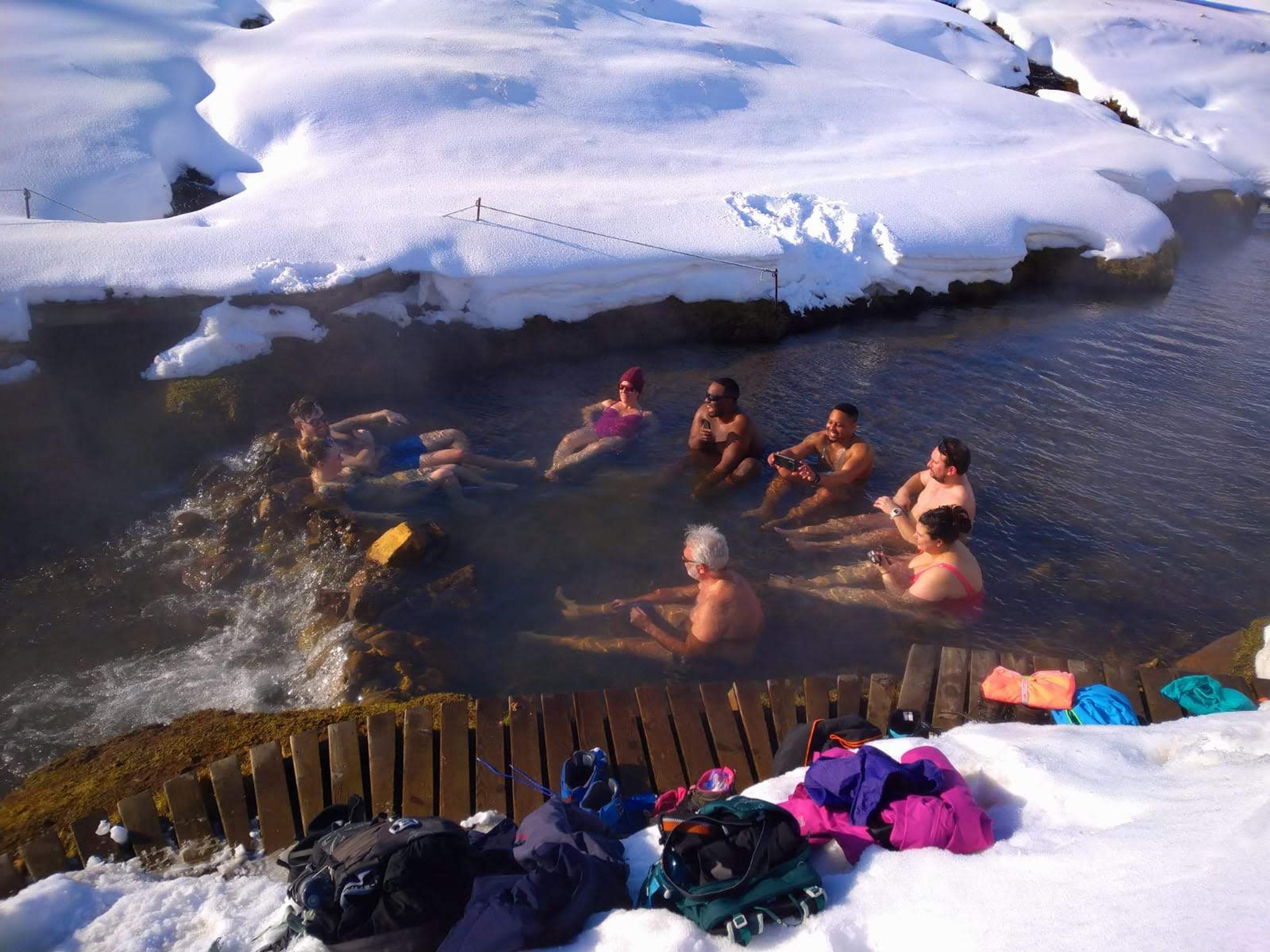 A group of people bathing in a hot spring during winter