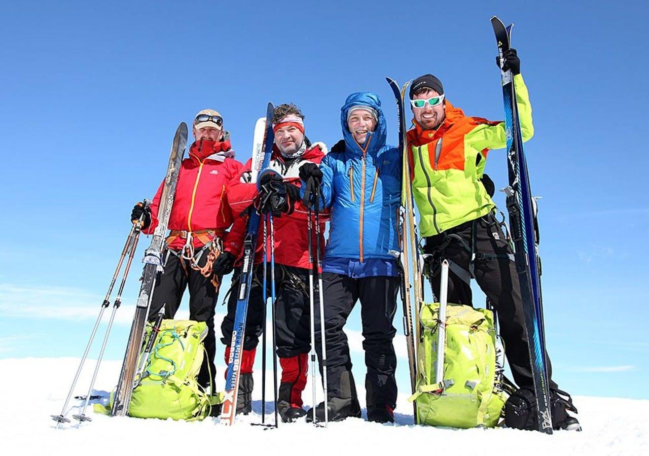 A group photo of men holding their skis on a glacier crossing tour with Icelandic Mountain Guides