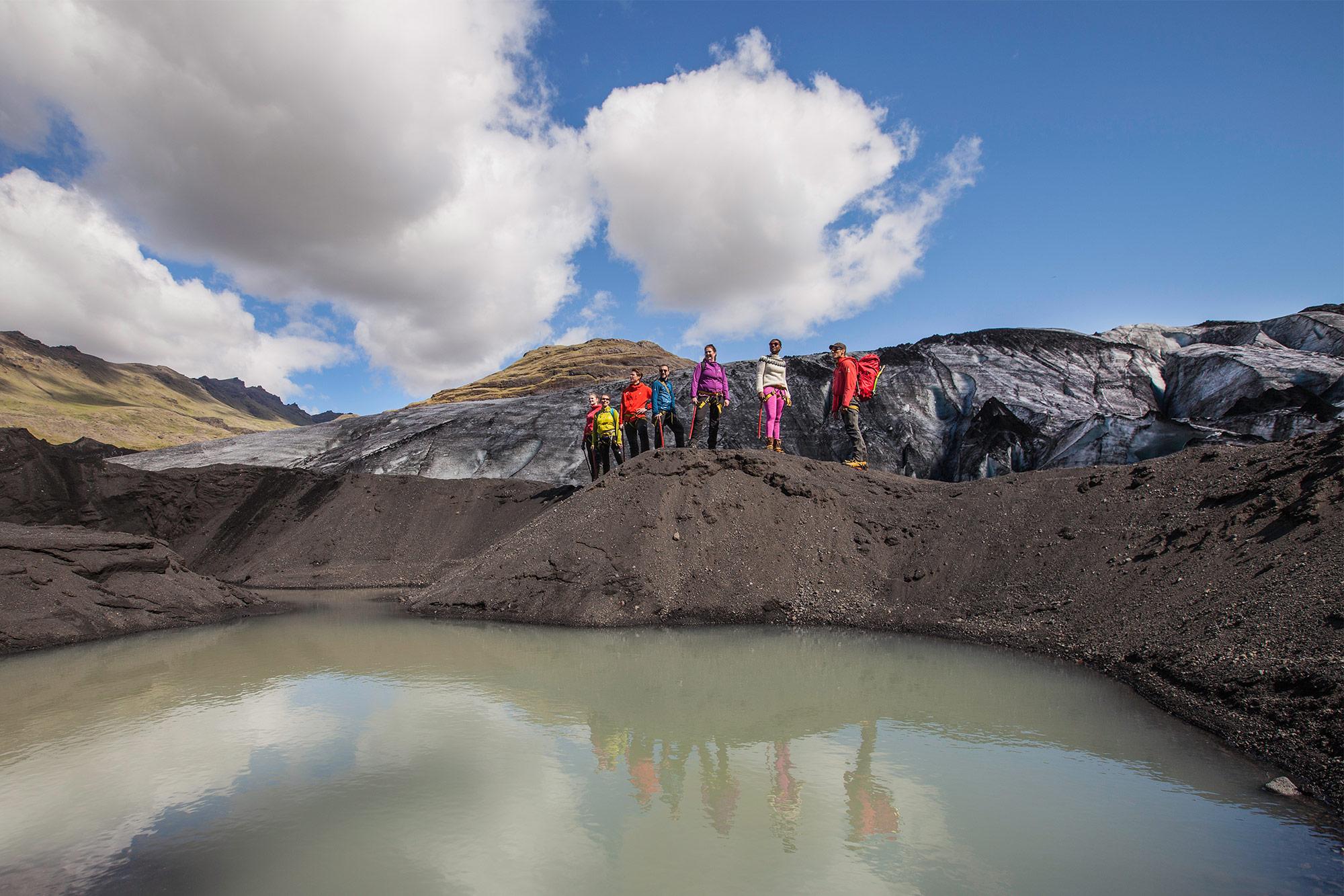 Group of explorers by the glacial lagoon in Sólheimajökull