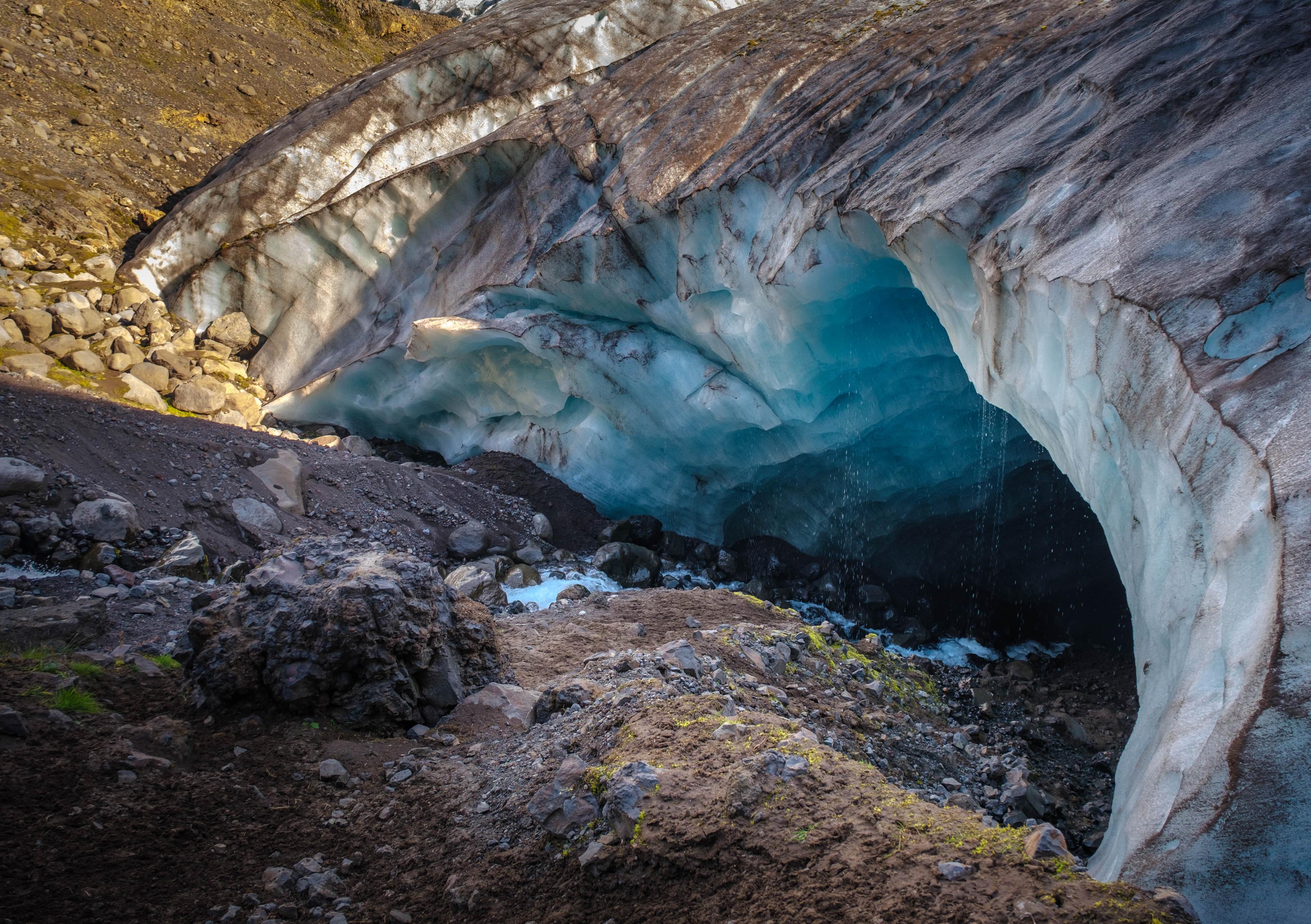 An entrance to a beautiful blue ice cave
