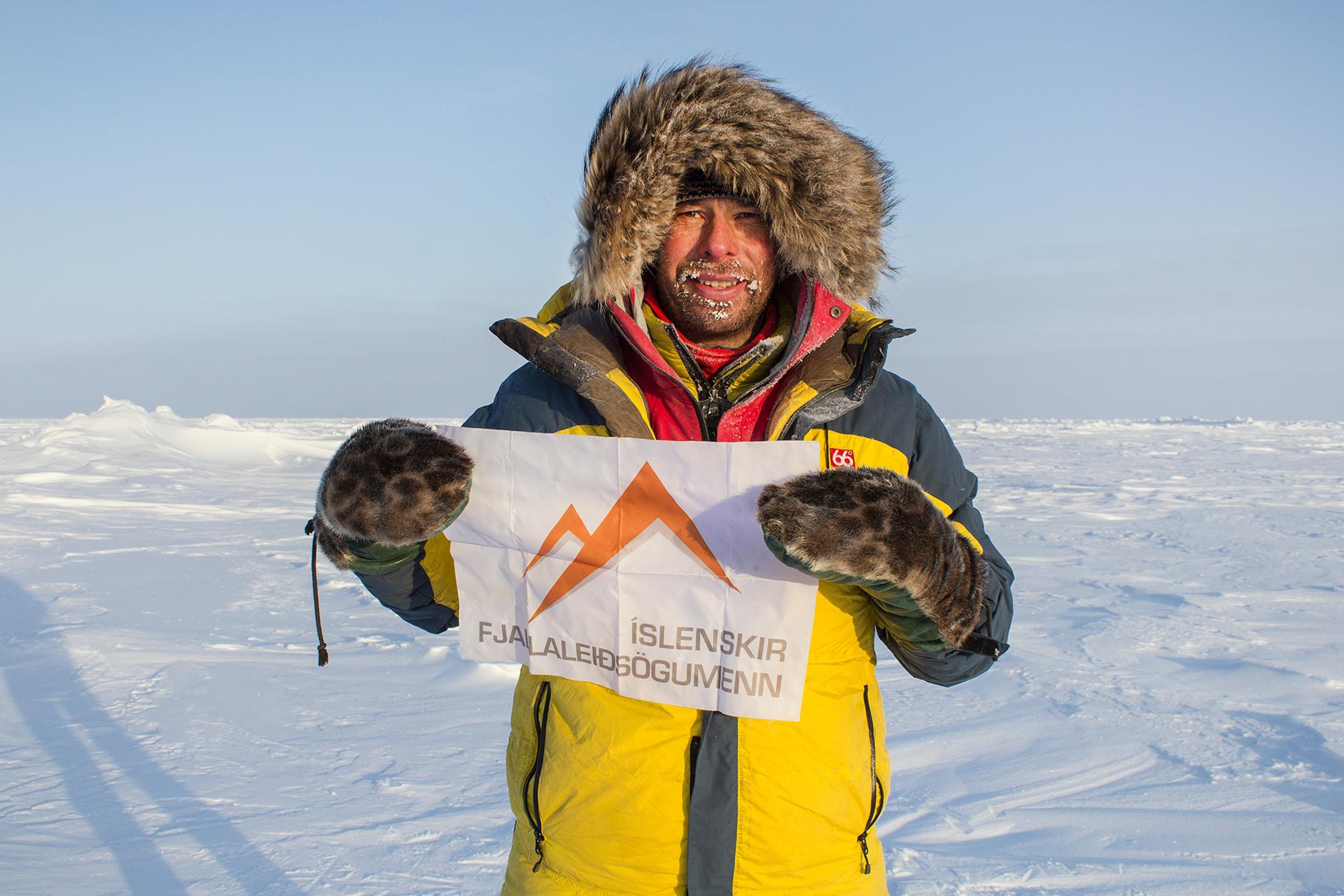 An expedition leader with the Icelandic Mountain Guides flag on the North Pole