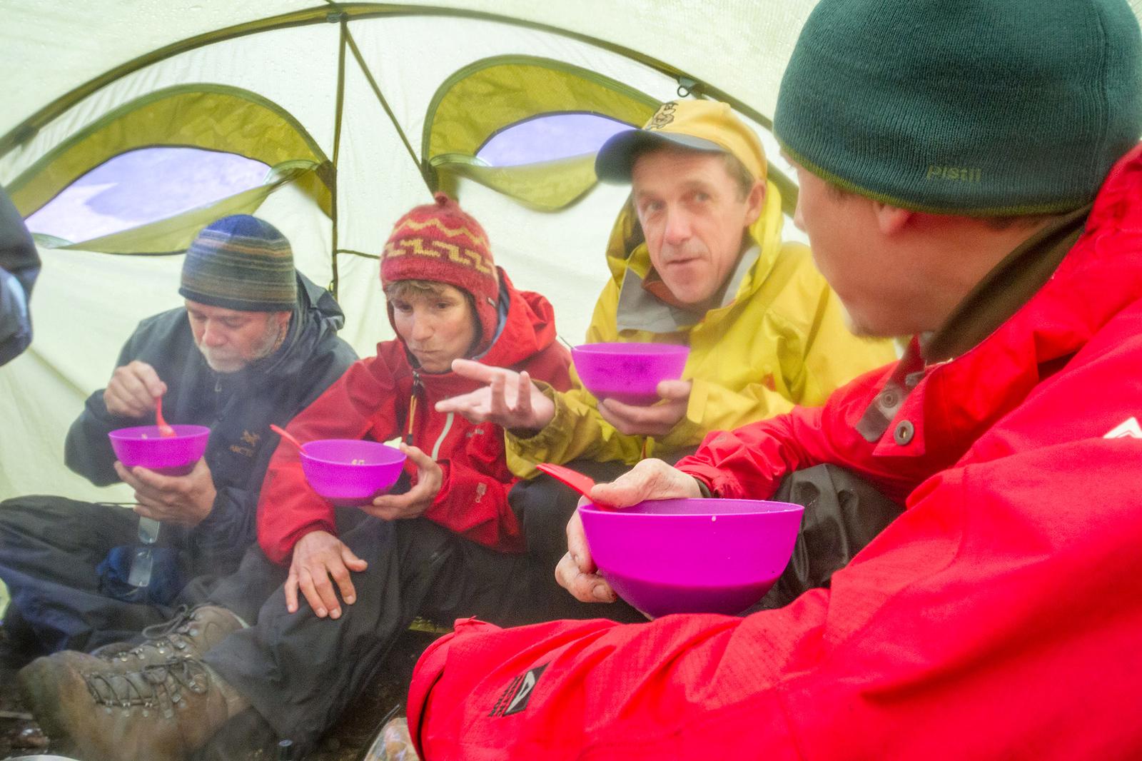 explorers with their guide enjoying some snacks inside their tent