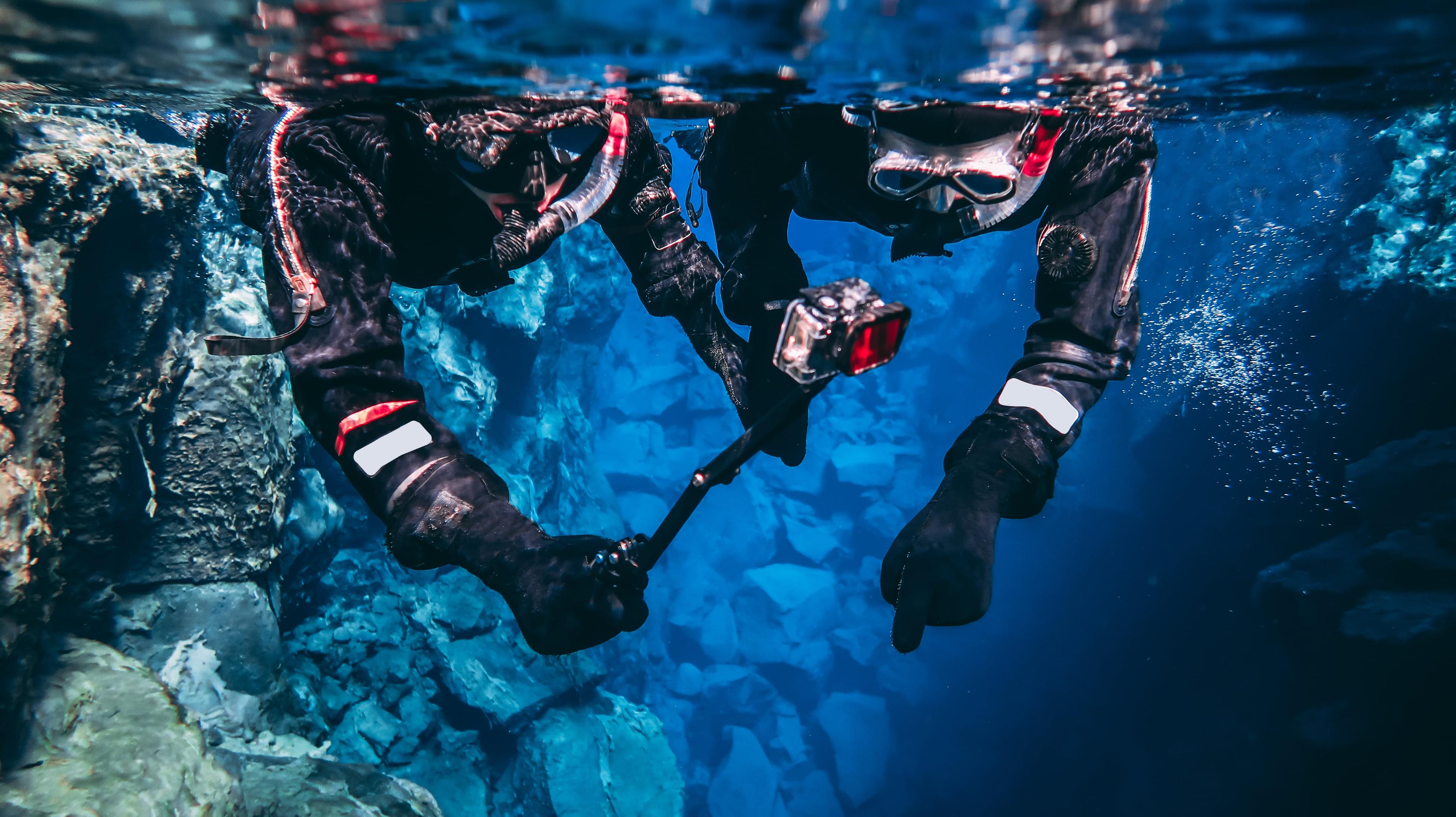 Two people taking photos with a go-pro while underwater