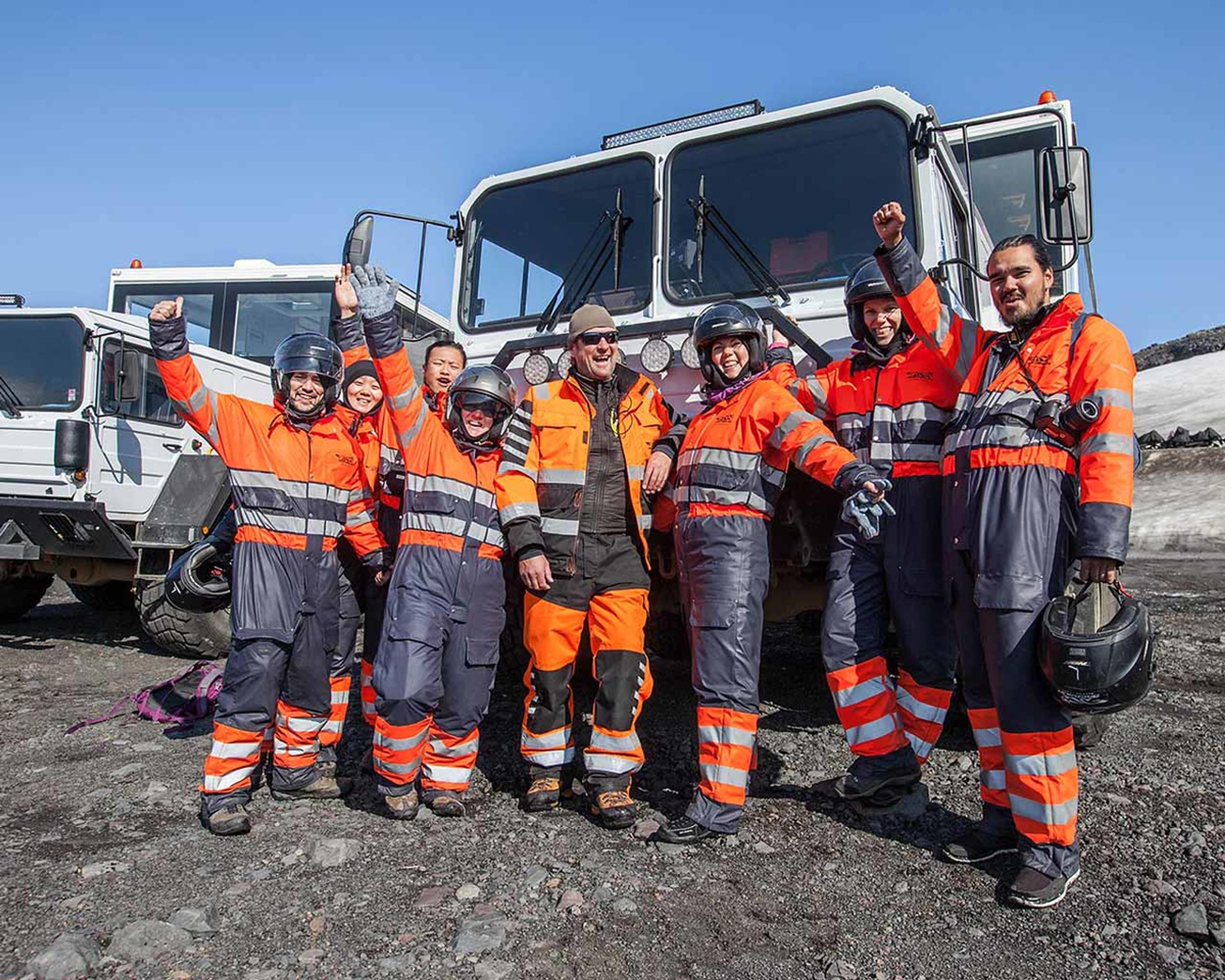 A group photo of the snow mobile riders after the tour in front of the glacier trucks