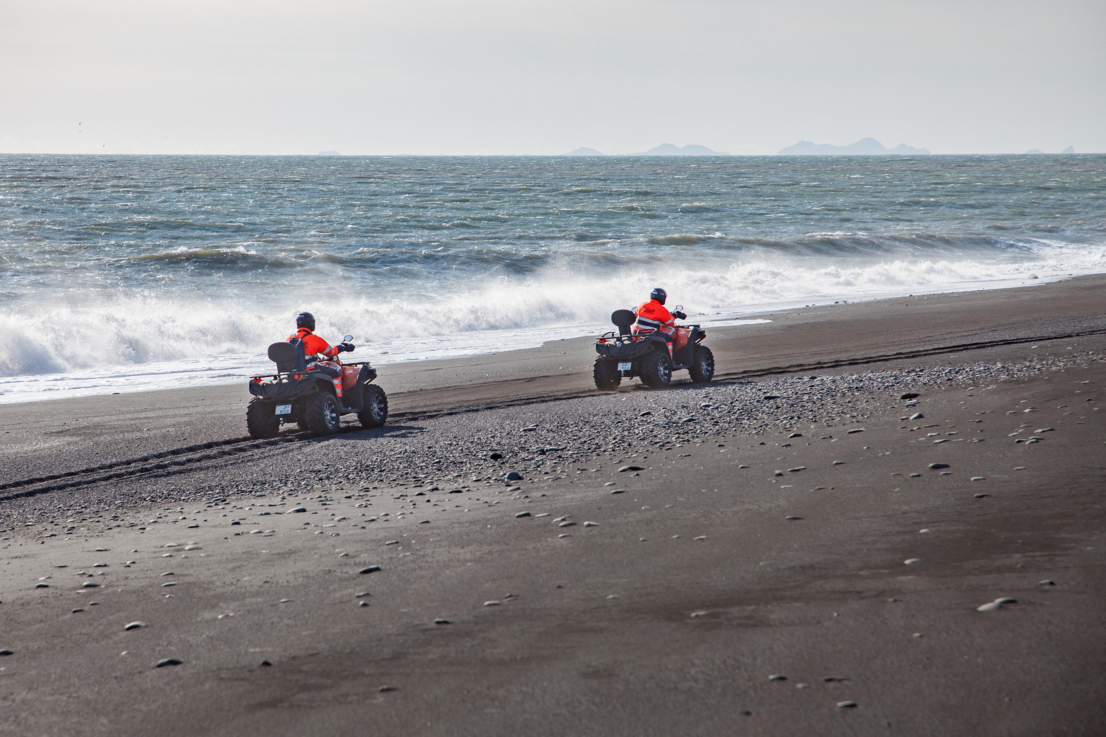 ATV/quad bike riders going a long the black beach on Iceland's south coast