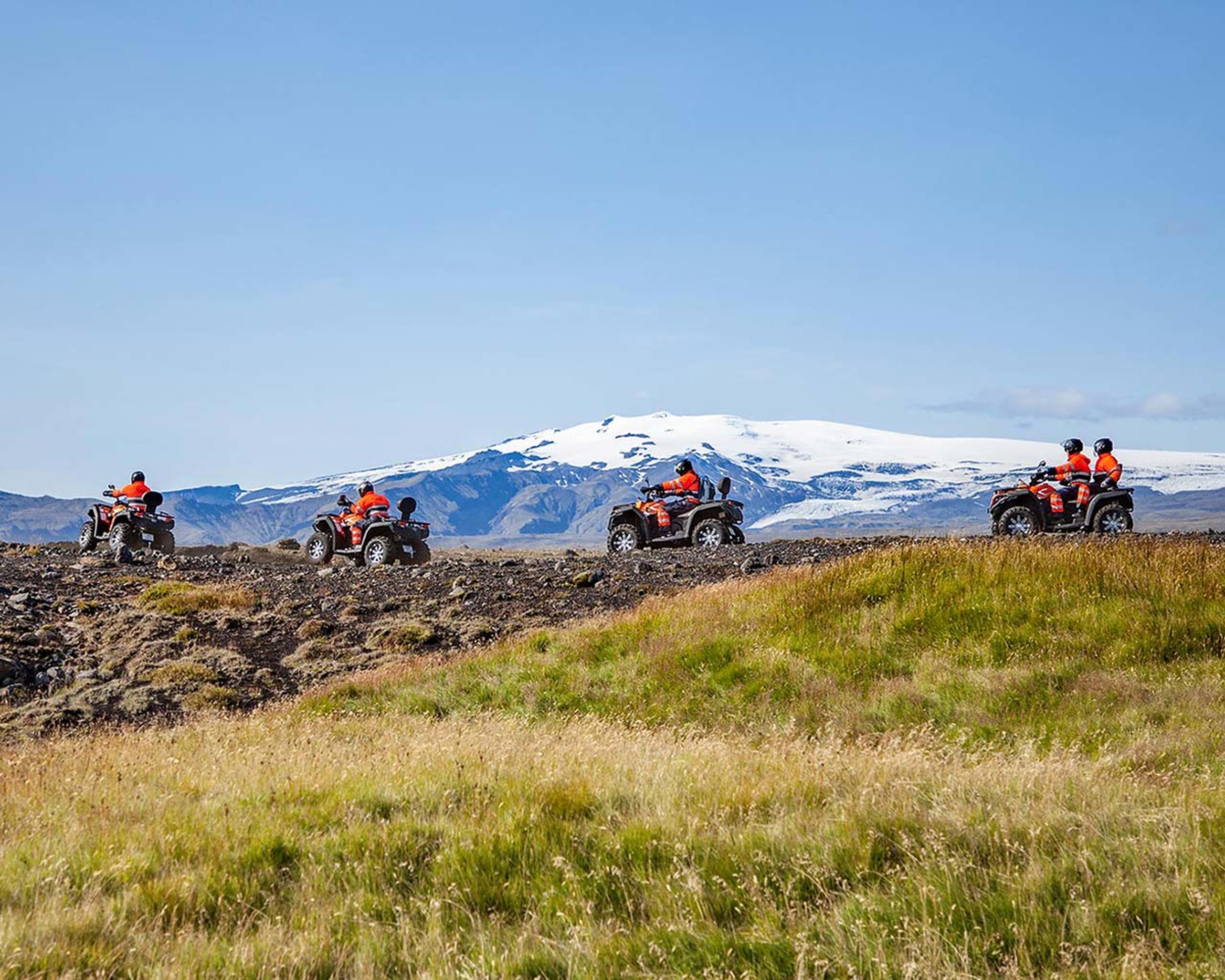 Driving past a grassy field and a Eyjafjallajökull glacier in the background