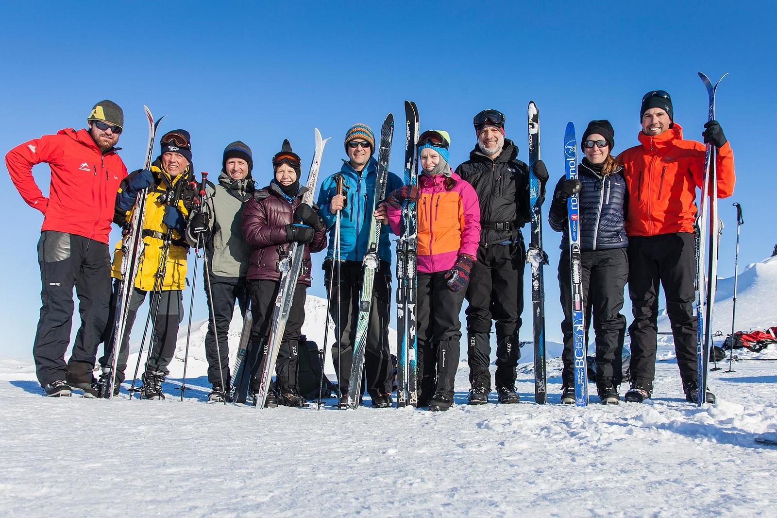 Guide from Icelandic Mountain Guides in red jacket and sunglasses poses with happy tourists