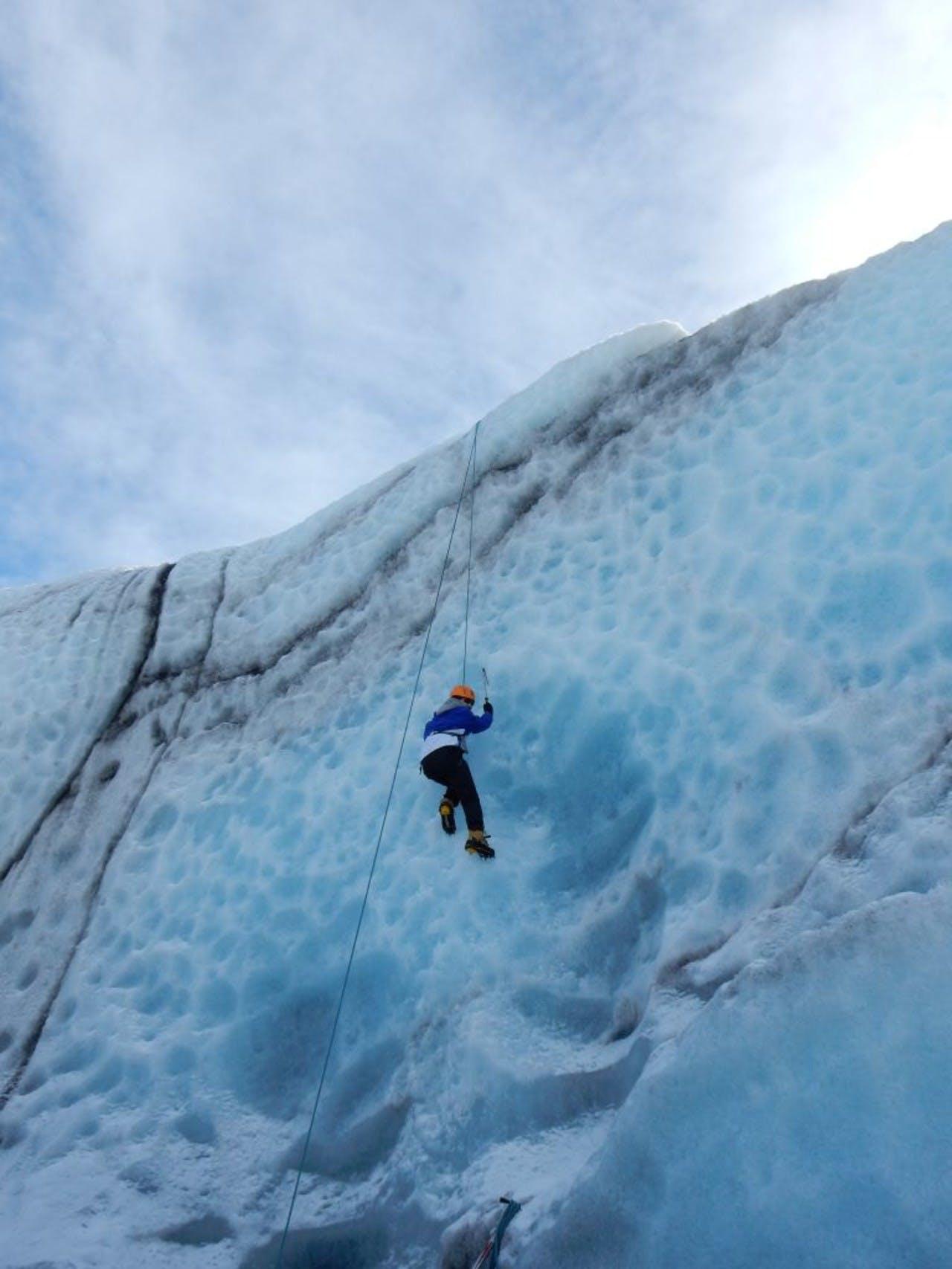 Man climbing up a glacier on a sunny day
