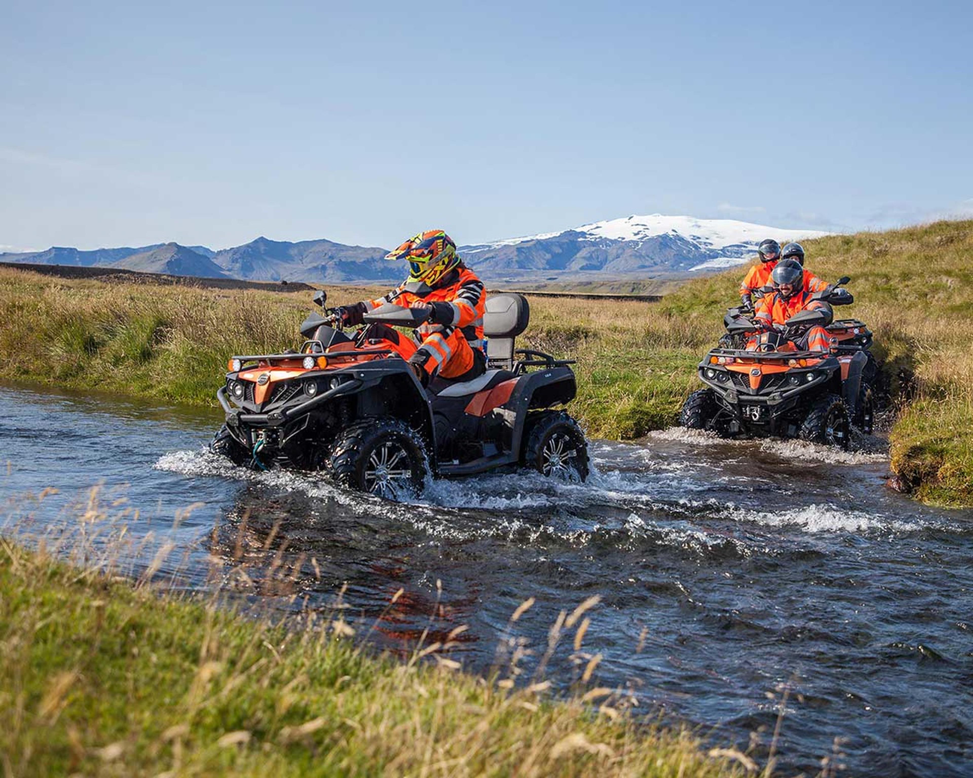 Crossing river on a quad bike and a glacier in the background