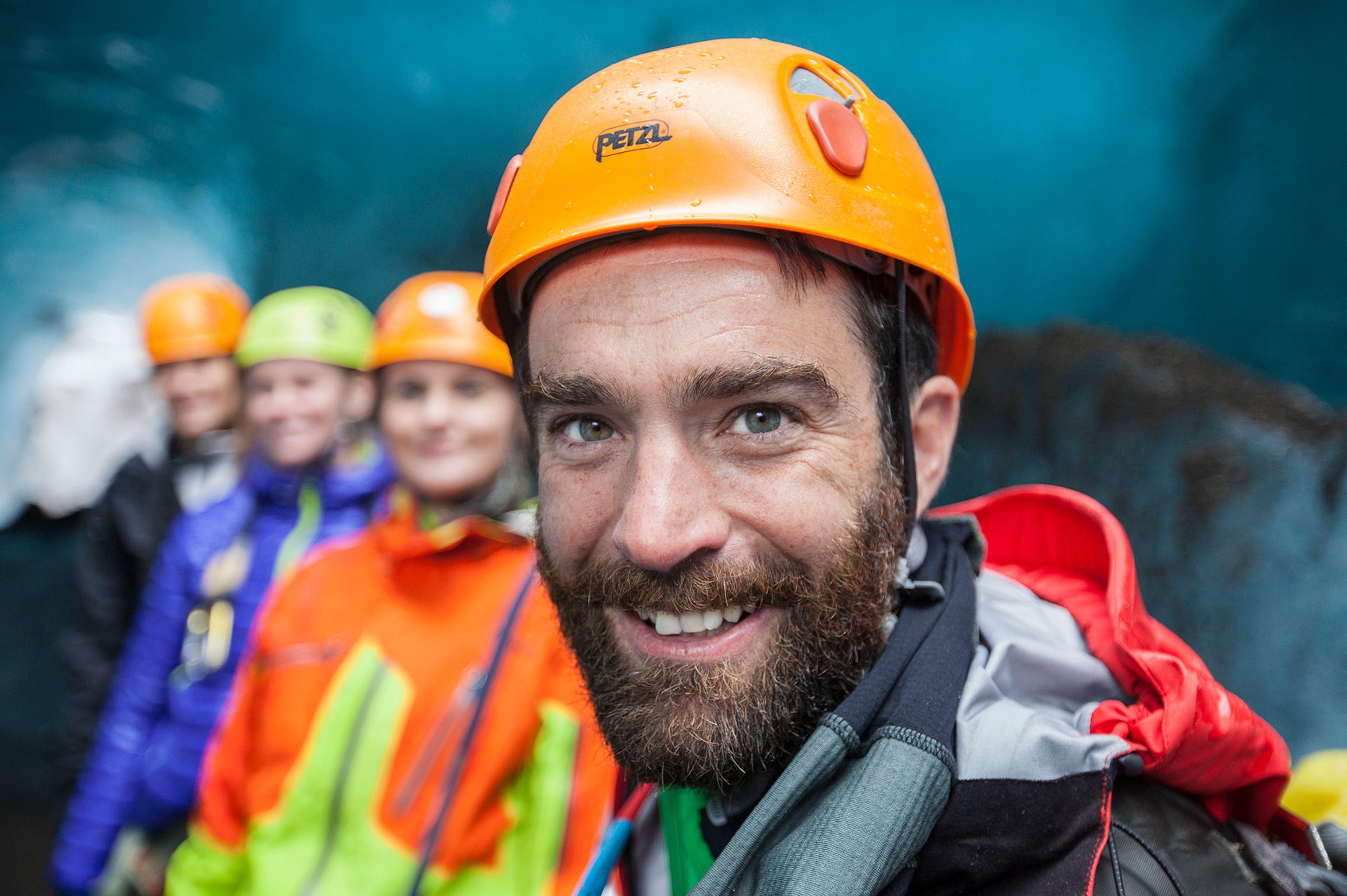 A guide and his group inside an ice cave