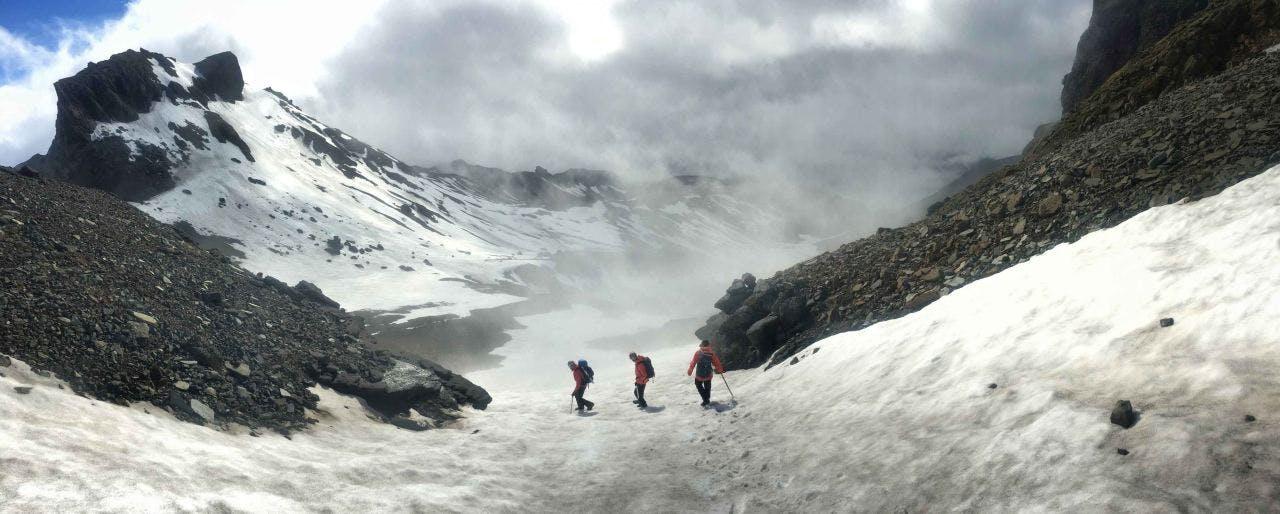 Hikers going down a snowy hill from Hrútfjallstindar on a tour with Icelandic Mountain Guides