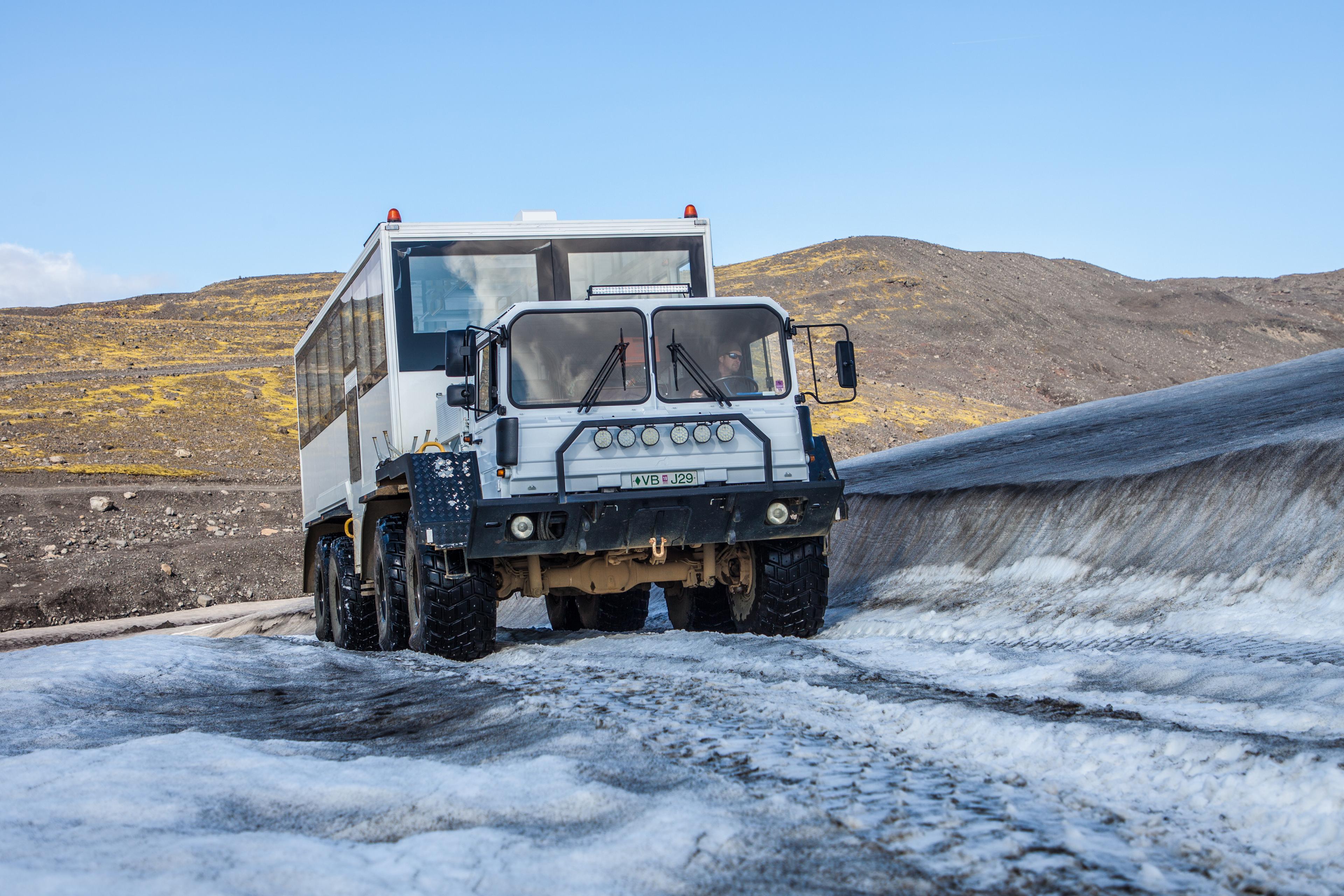 The glacier monster truck driving on snow on the way down to base