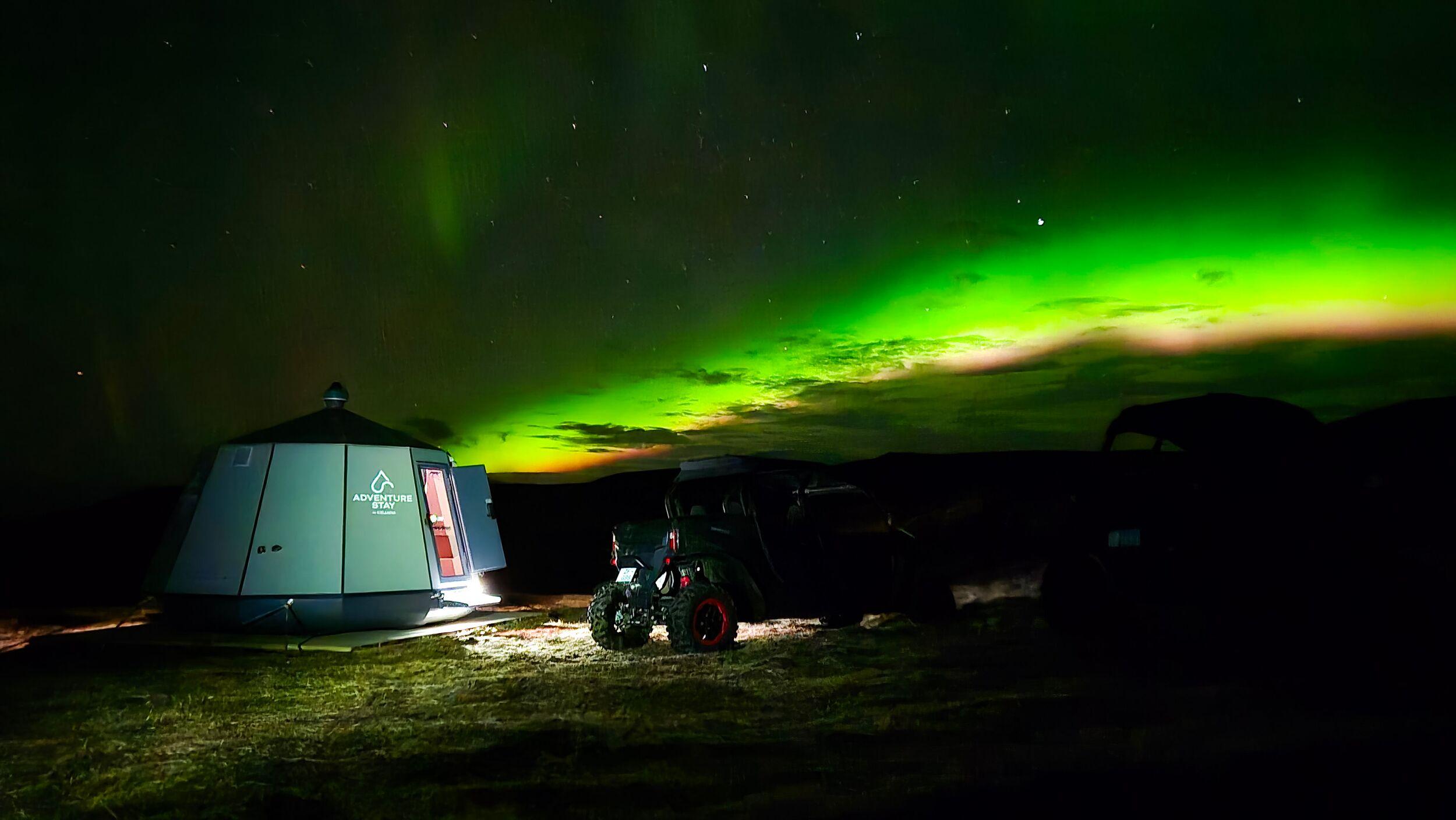 An Adventure Stay hut with northern lights across the sky