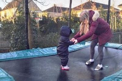 Moeder en kind springen hand in hand op de trampoline