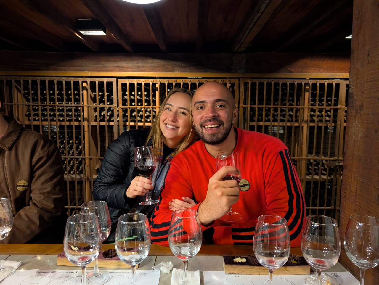 A couple toasting with wine glasses at the cellar tasting table