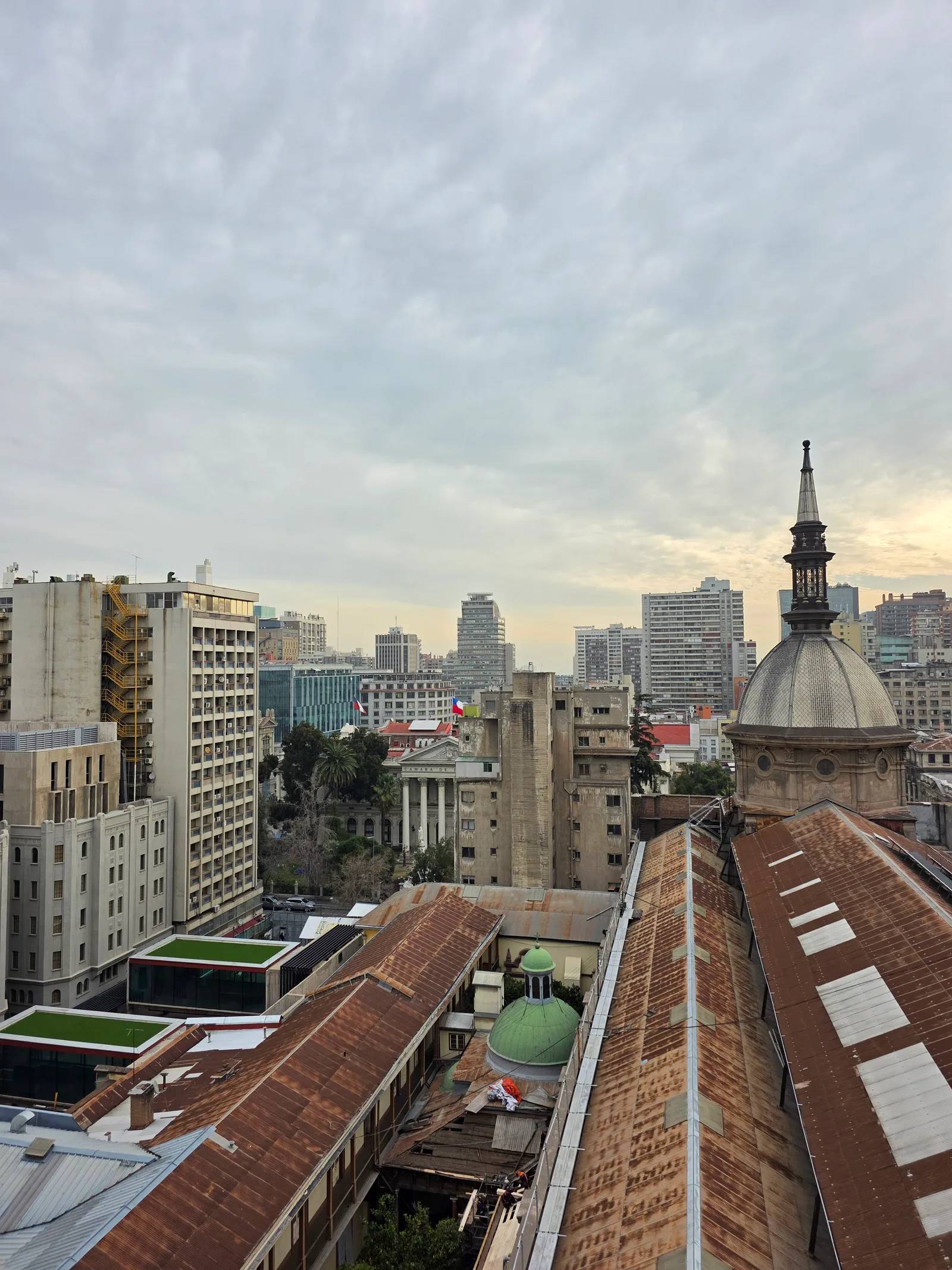 A rooftop view over downtown Santiago with a domed church tower in the foreground