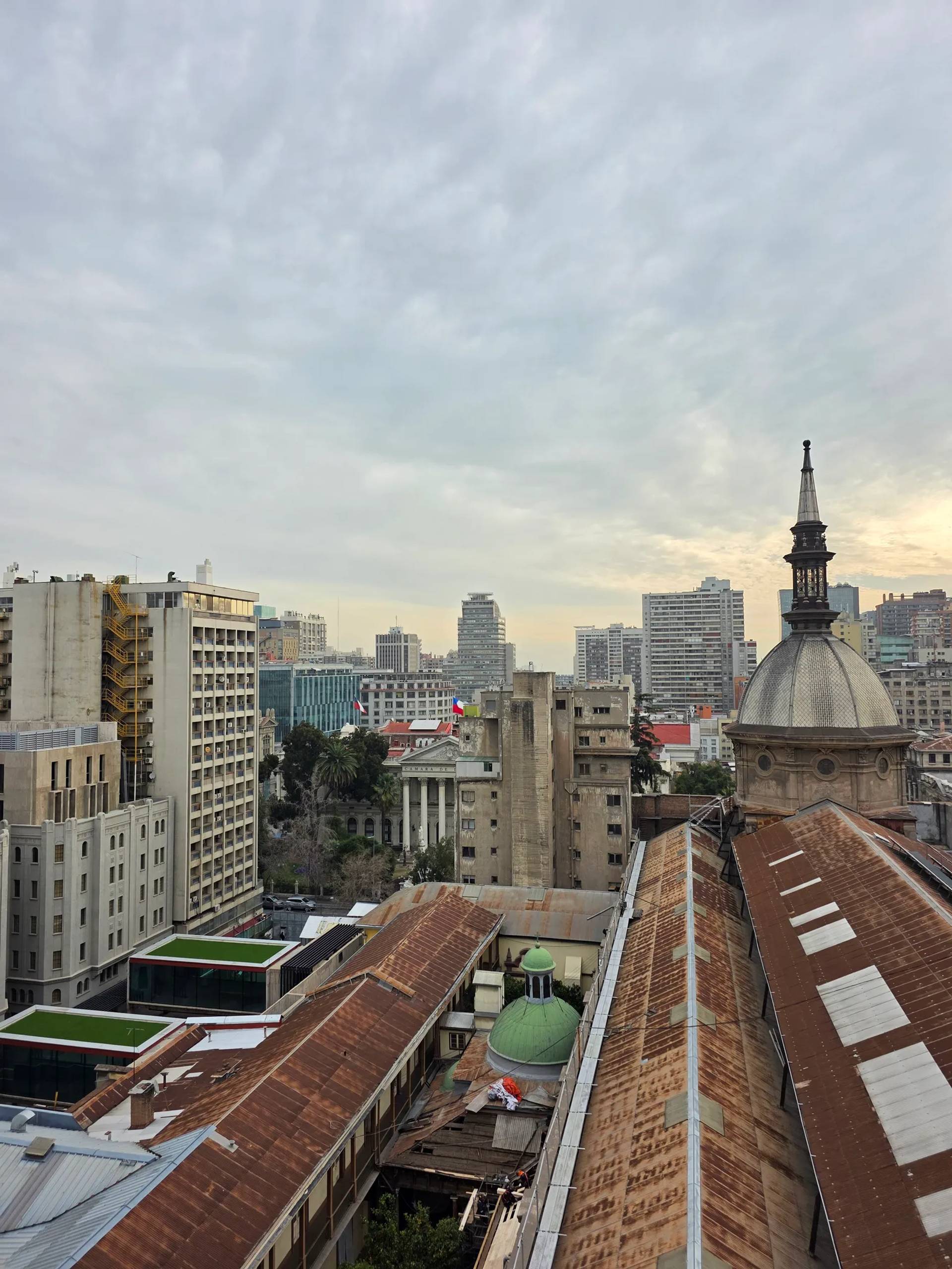 A rooftop view over downtown Santiago with a domed church tower in the foreground