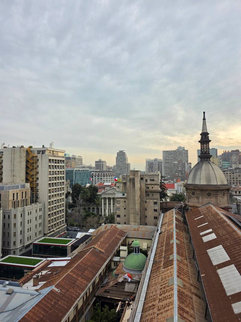A rooftop view over downtown Santiago with a domed church tower in the foreground