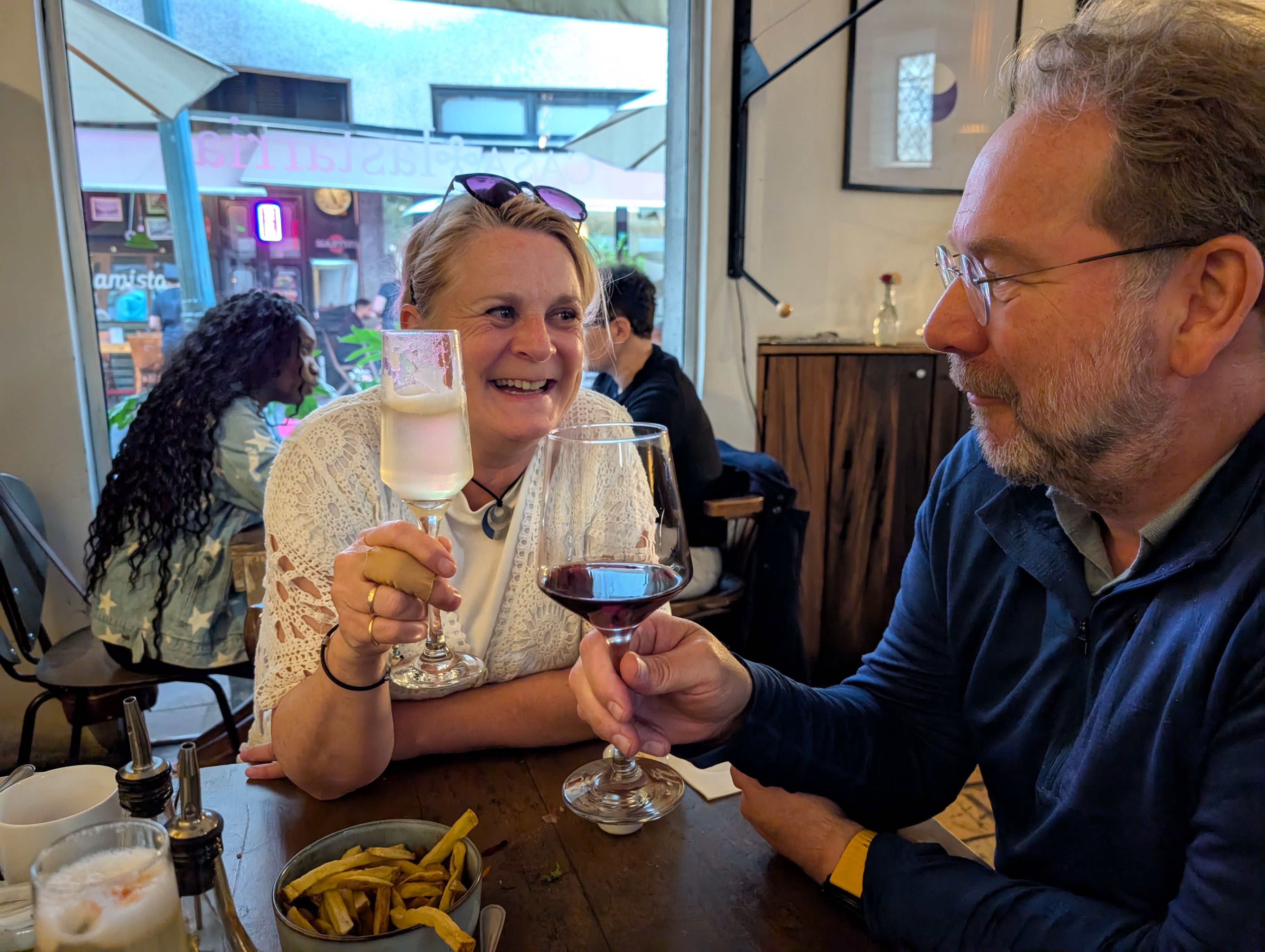 A couple raising their wine glasses together at the restaurant table