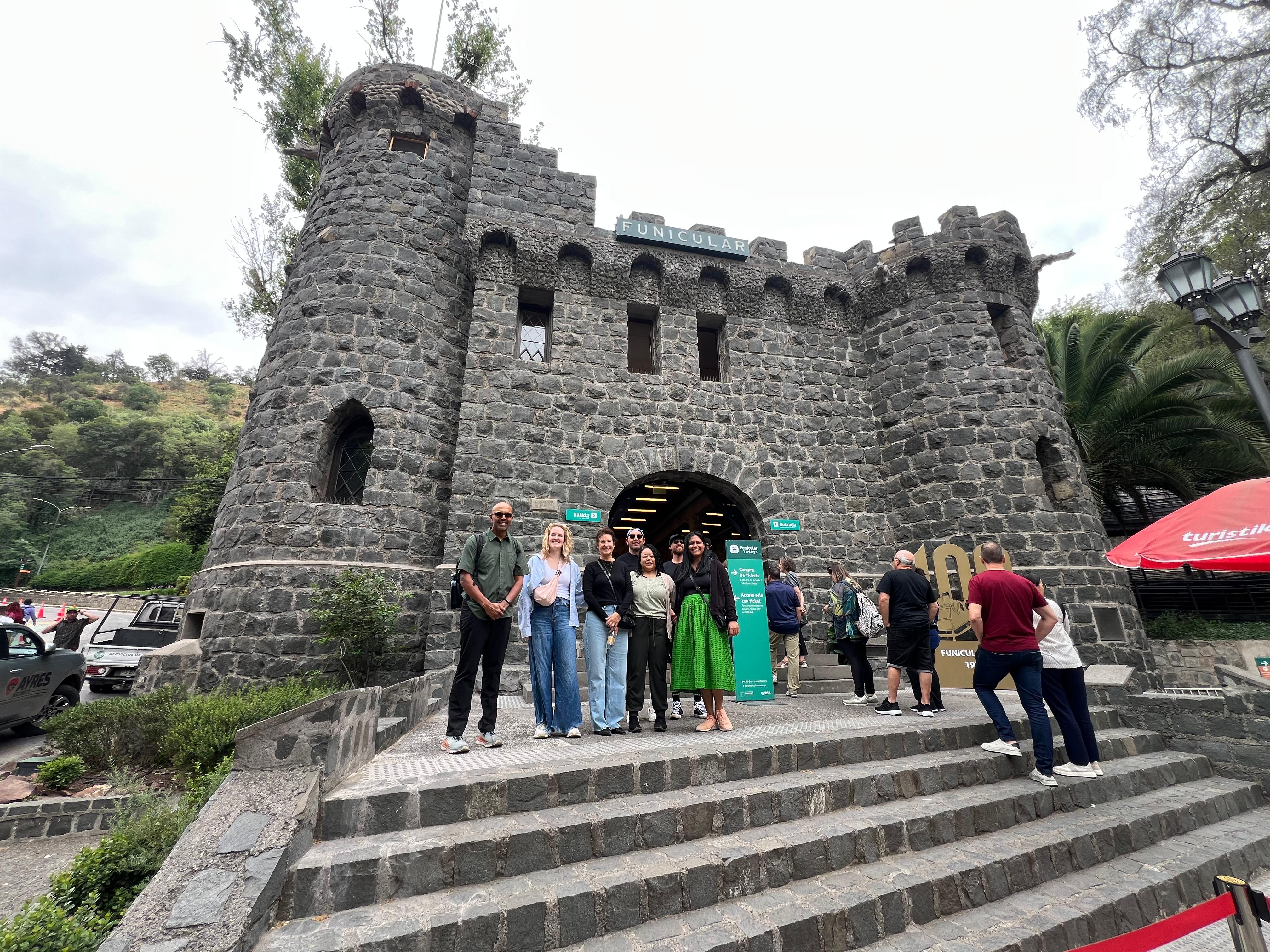 Visitors climbing the steps of a stone castle-like lookout tower