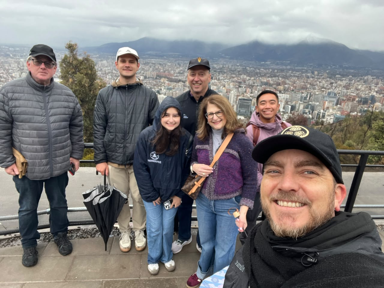 A group posing together on a viewpoint overlooking the city