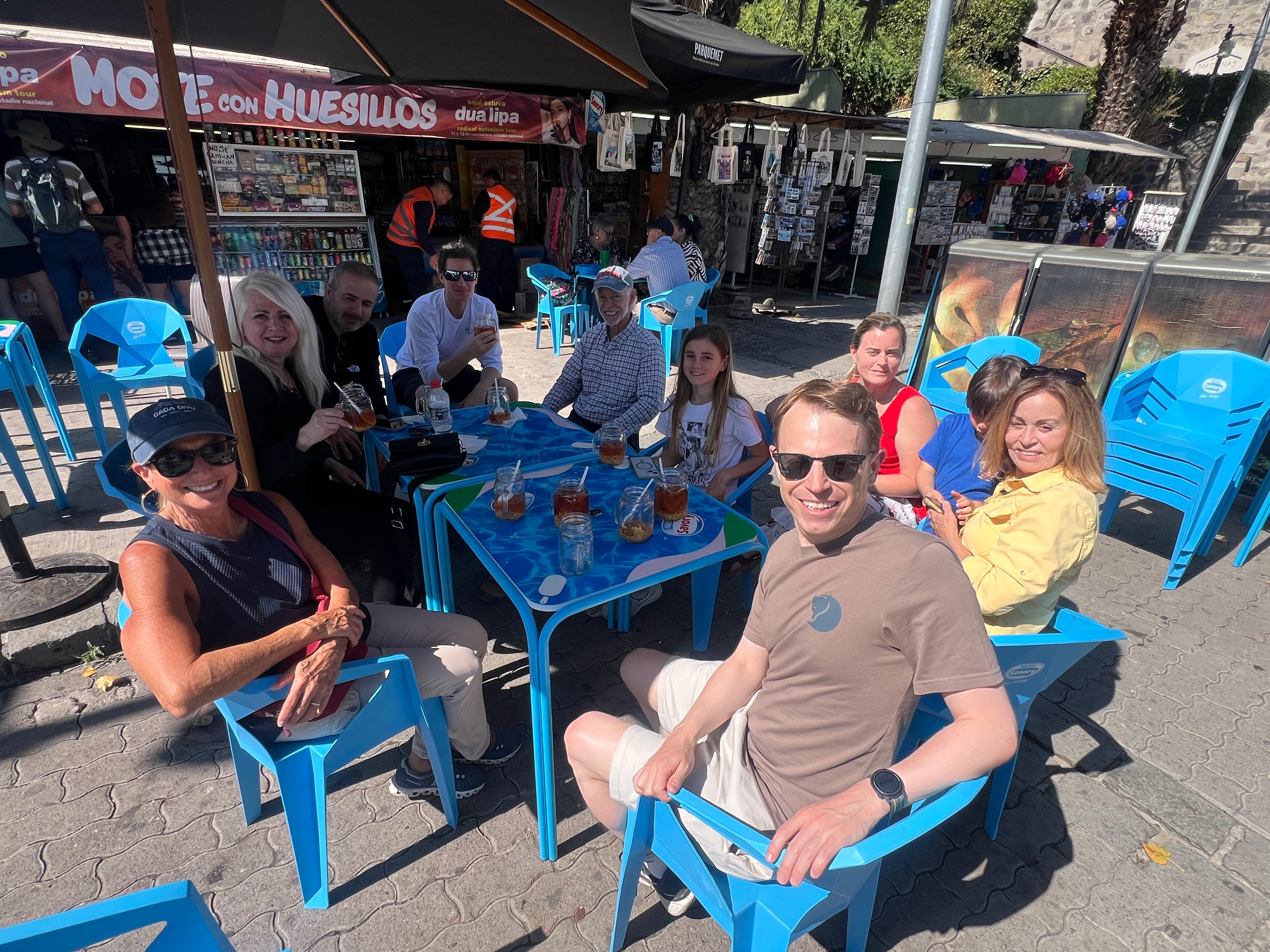 Visitors relaxing at outdoor blue tables near the cable car station