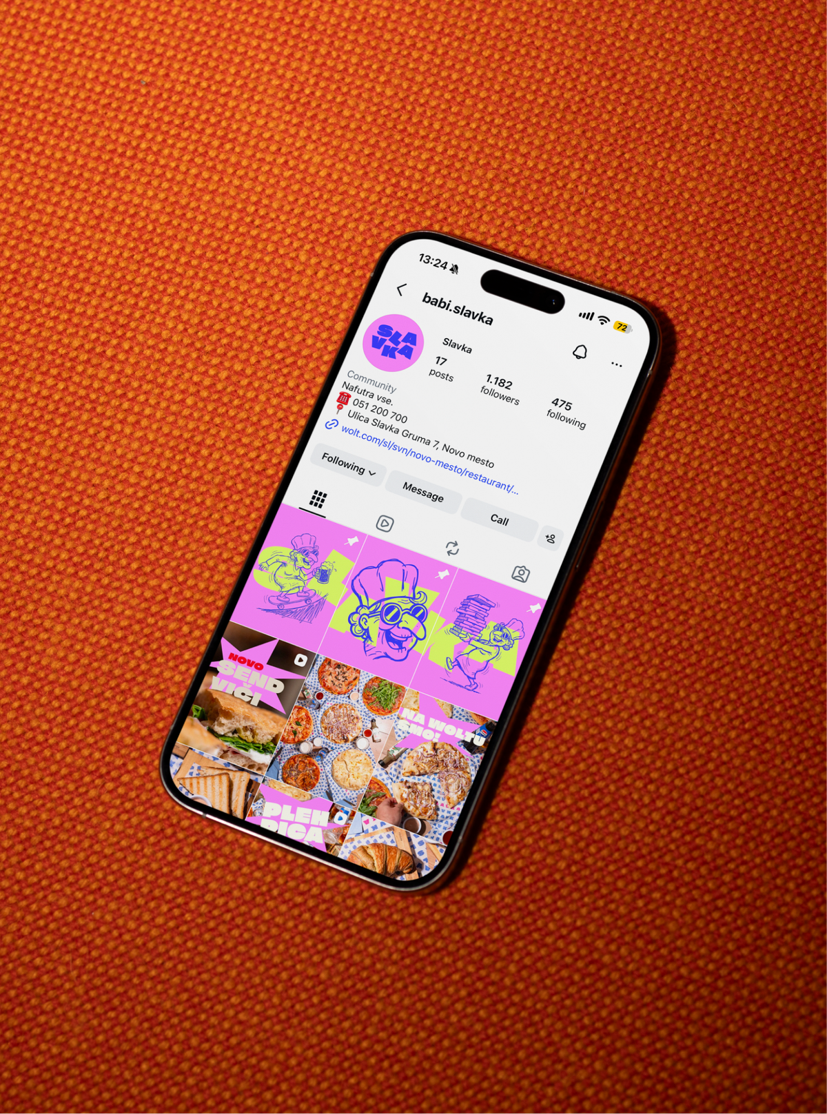 A phone on orange fabric, open on the babi.slavka Instagram profile of pink drawings and pizza photos.