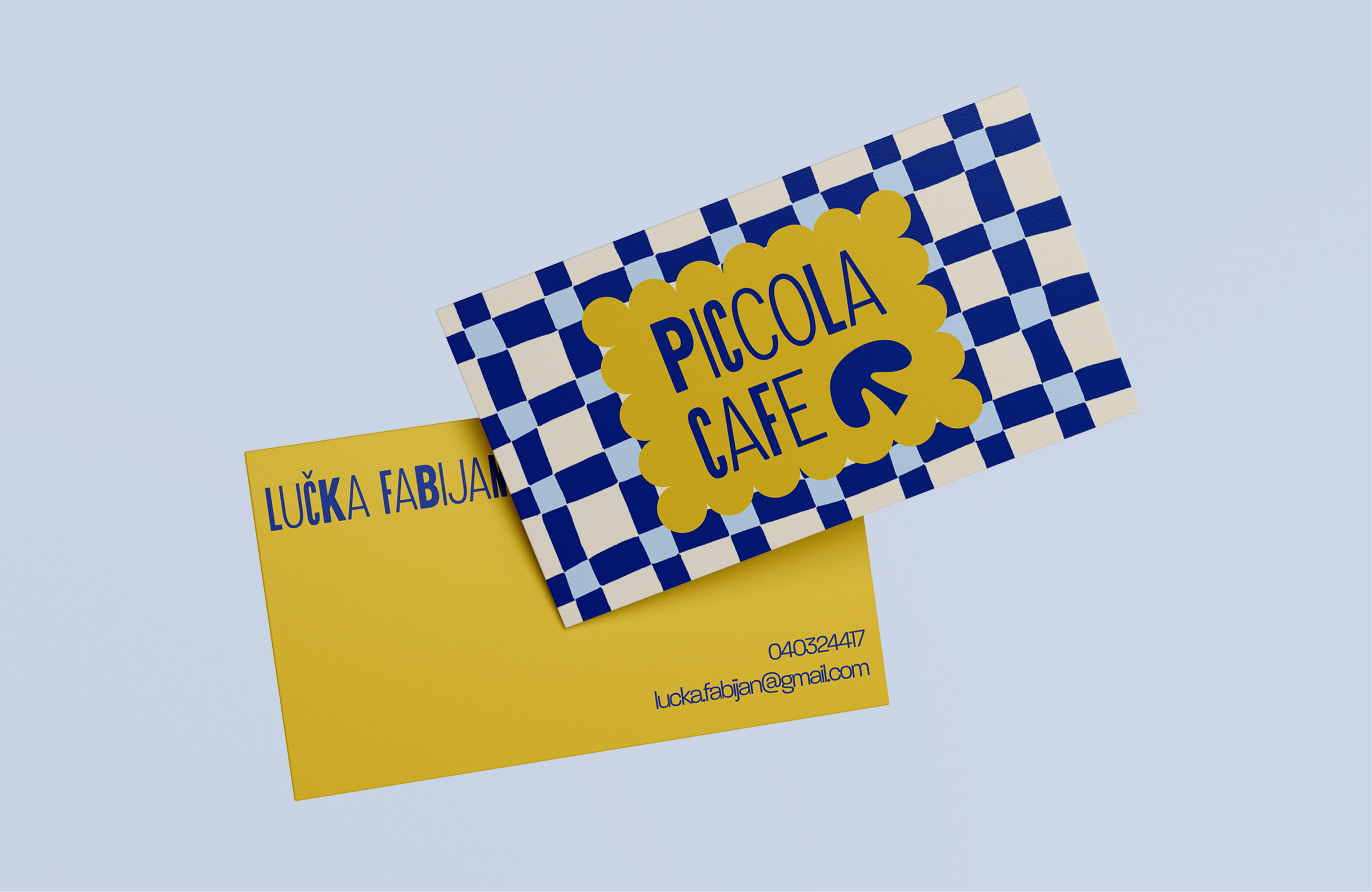 Two business cards, one in yellow and one in a blue checkerboard with the logo.