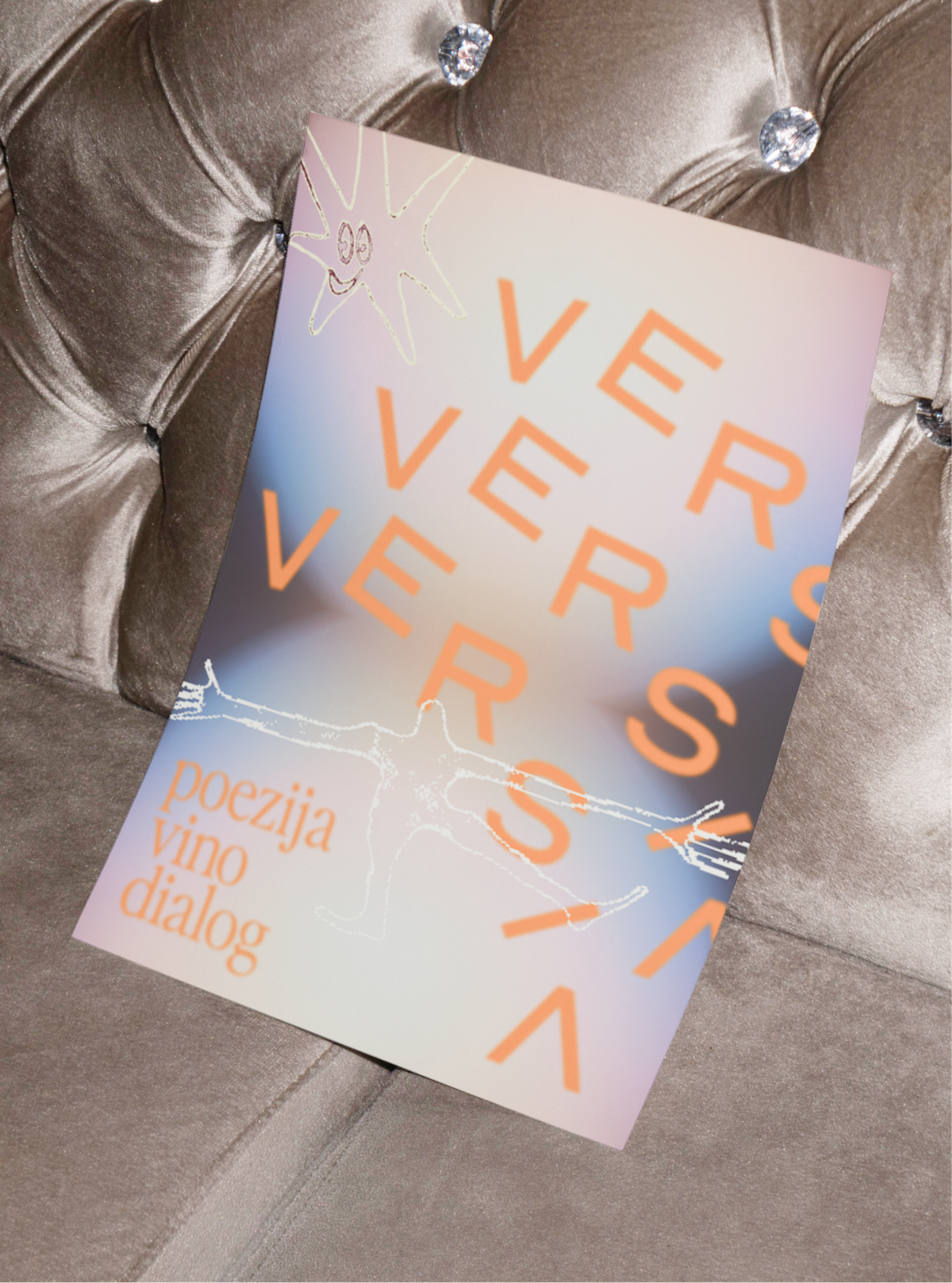 A lilac and orange Versia poster with a line-drawn figure, on a velvet chair.