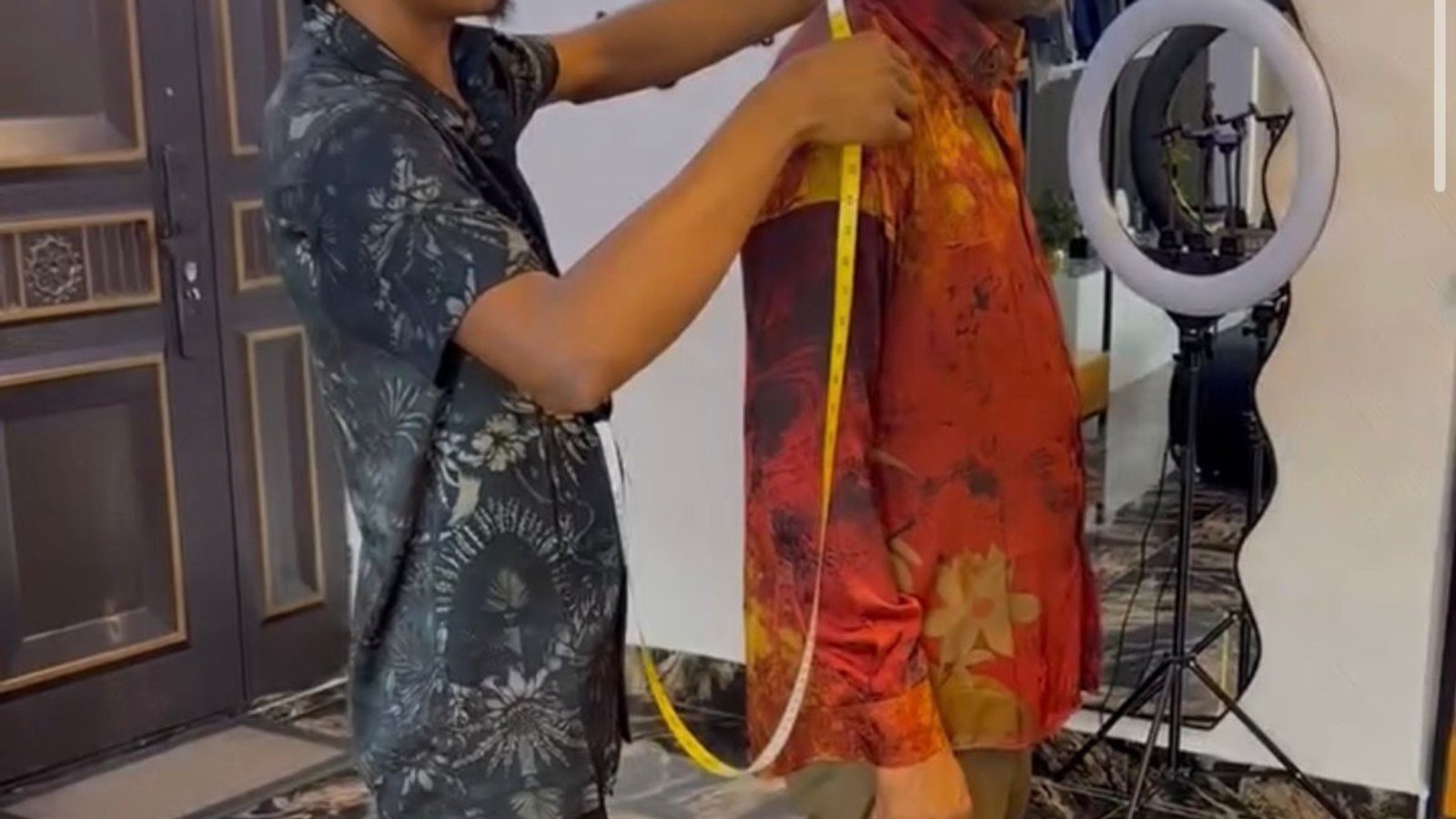 Man taking body measurements with a tape measure for a custom order.