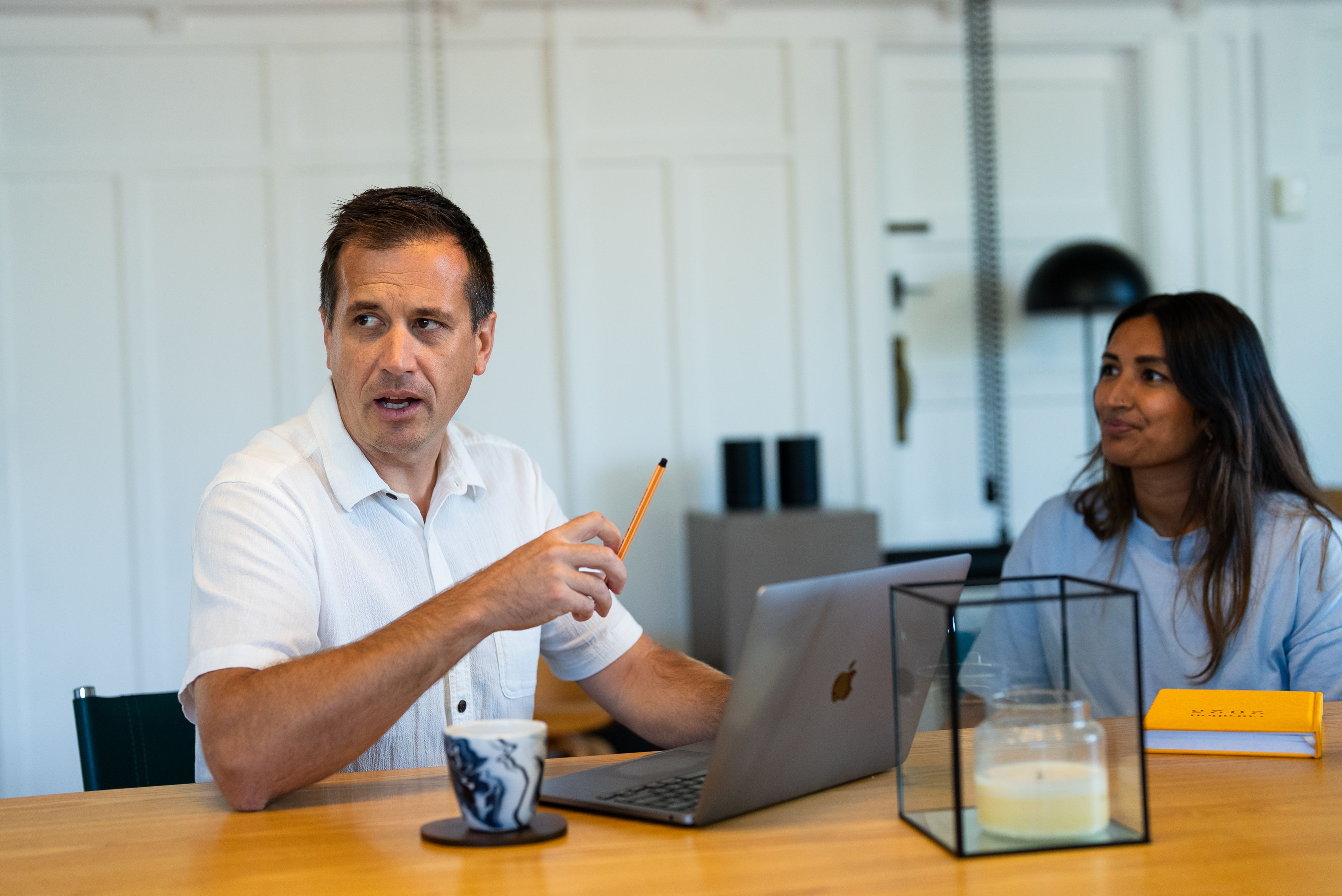 A Done By Nine marketer explaining the next move to a colleague, pencil in hand, over an open laptop