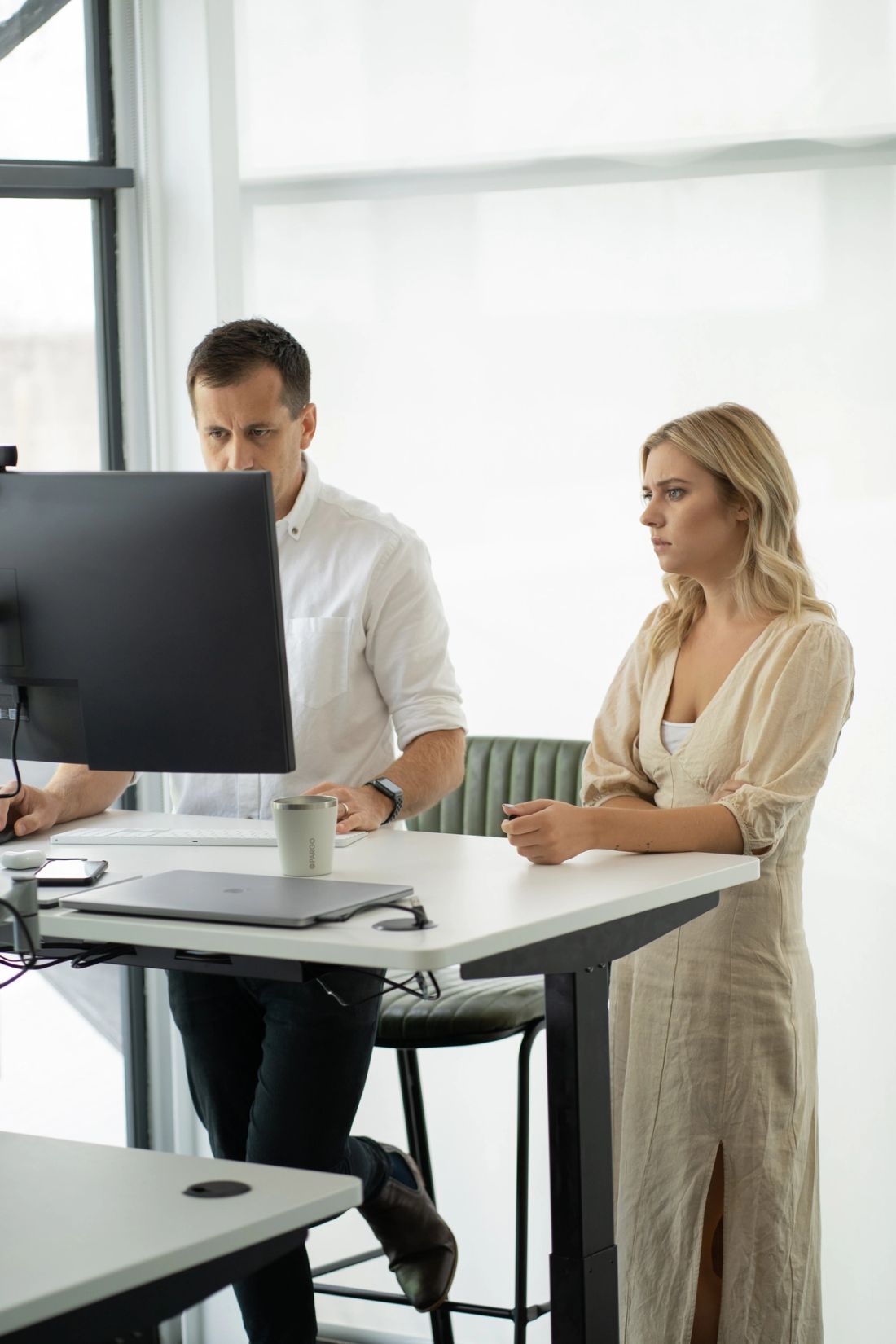 A Done By Nine marketer working at a desktop monitor while a colleague looks on