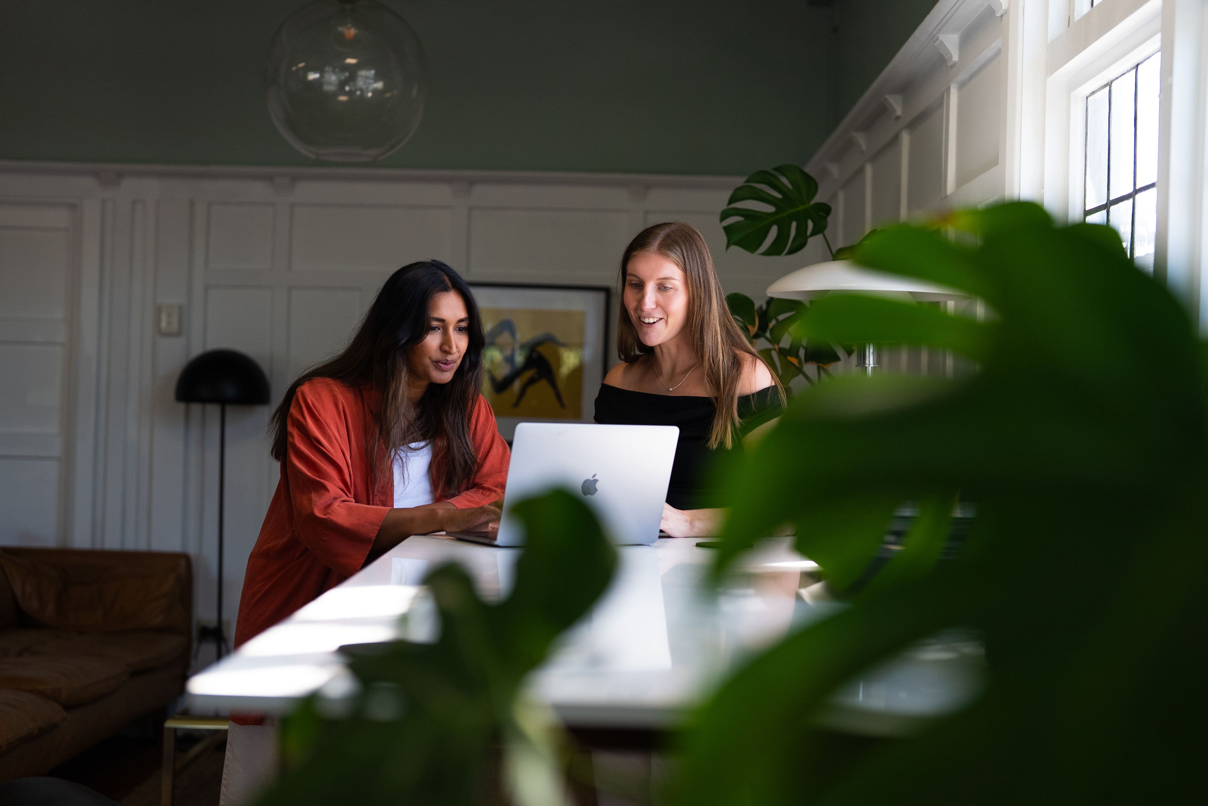 Two Done By Nine marketers at a laptop, one typing, both watching the work run on screen