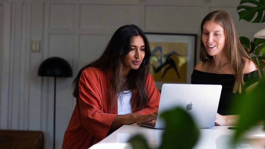 Two Done By Nine marketers at a laptop, one typing, both watching the work run on screen