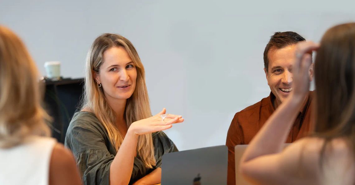 A Done By Nine strategist talking with clients across a meeting table