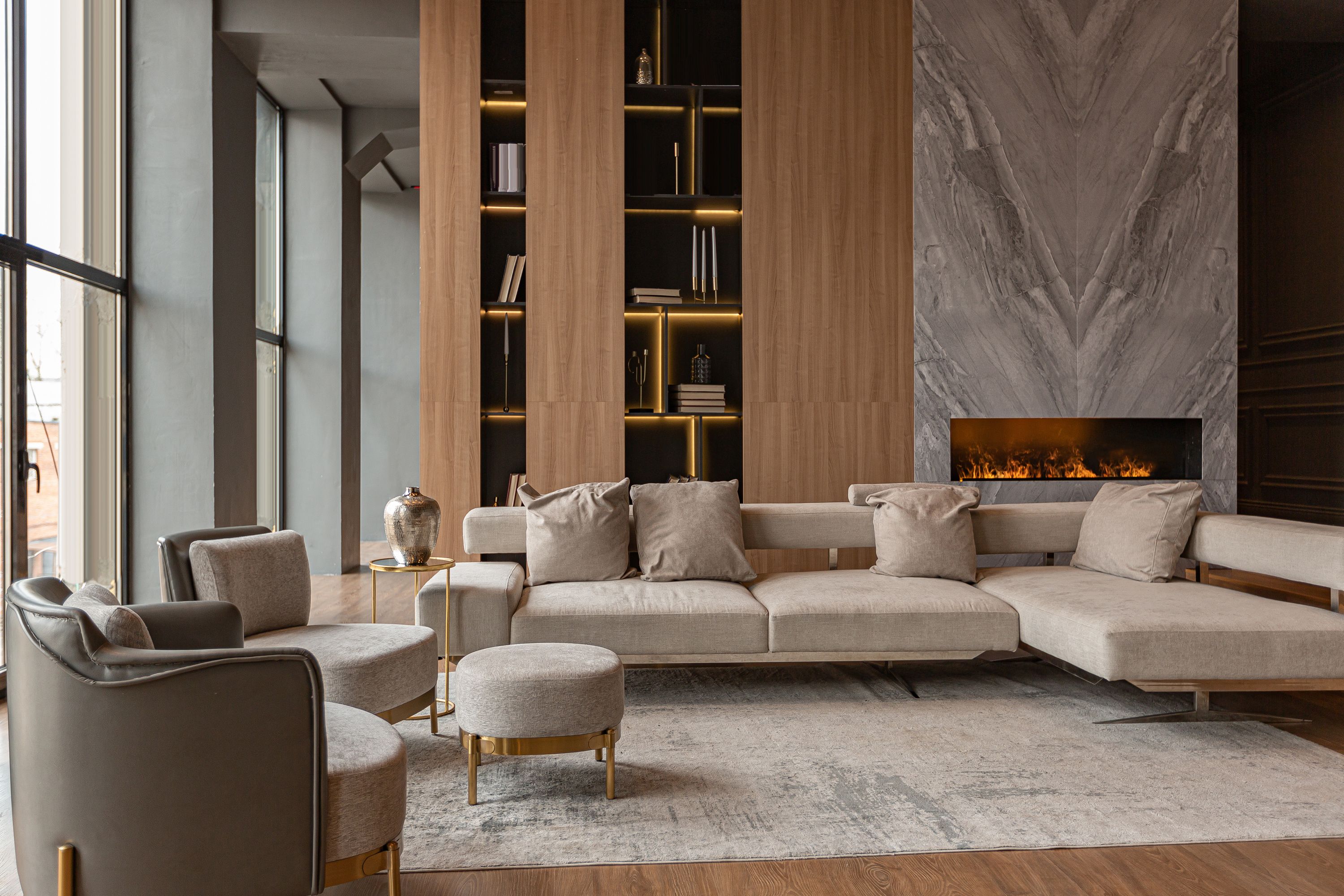 A tidy modern living room with a lit fireplace and wood shelving