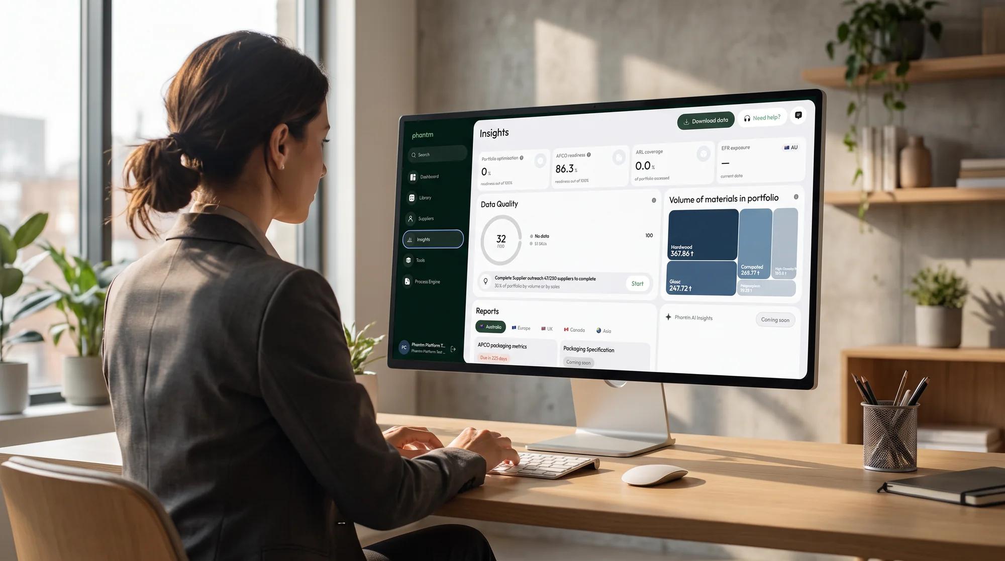 A team member reviewing the Phantm Insights dashboard on a large monitor at a bright office desk.