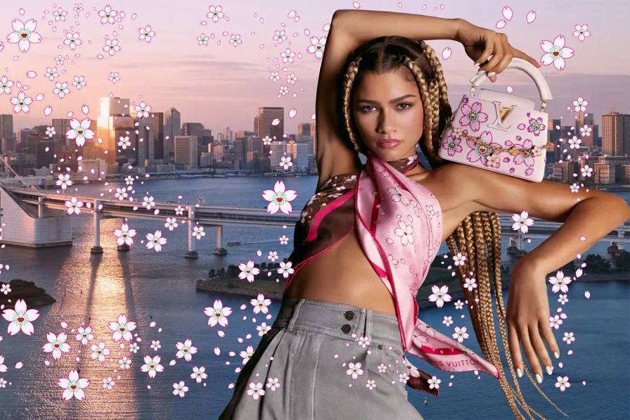 Louis Vuitton Zendaya modeling Louis Vuitton's new Cherry Blossom collection by Takashi Murakami, showcasing pink floral patterns on classic LV bags and accessories against a minimal background.
